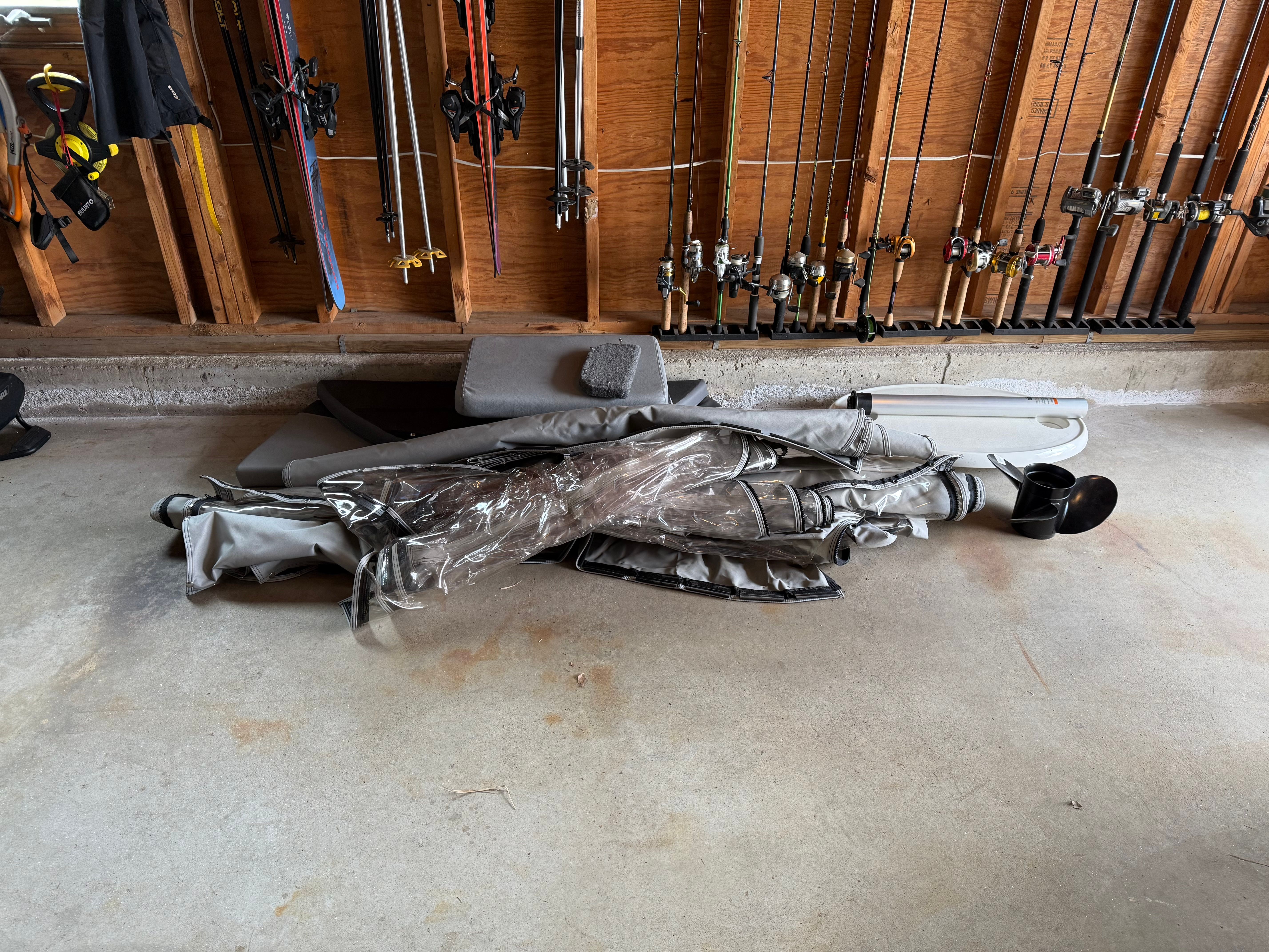Crestliner 1850 boat equipment in garage with fishing rods.