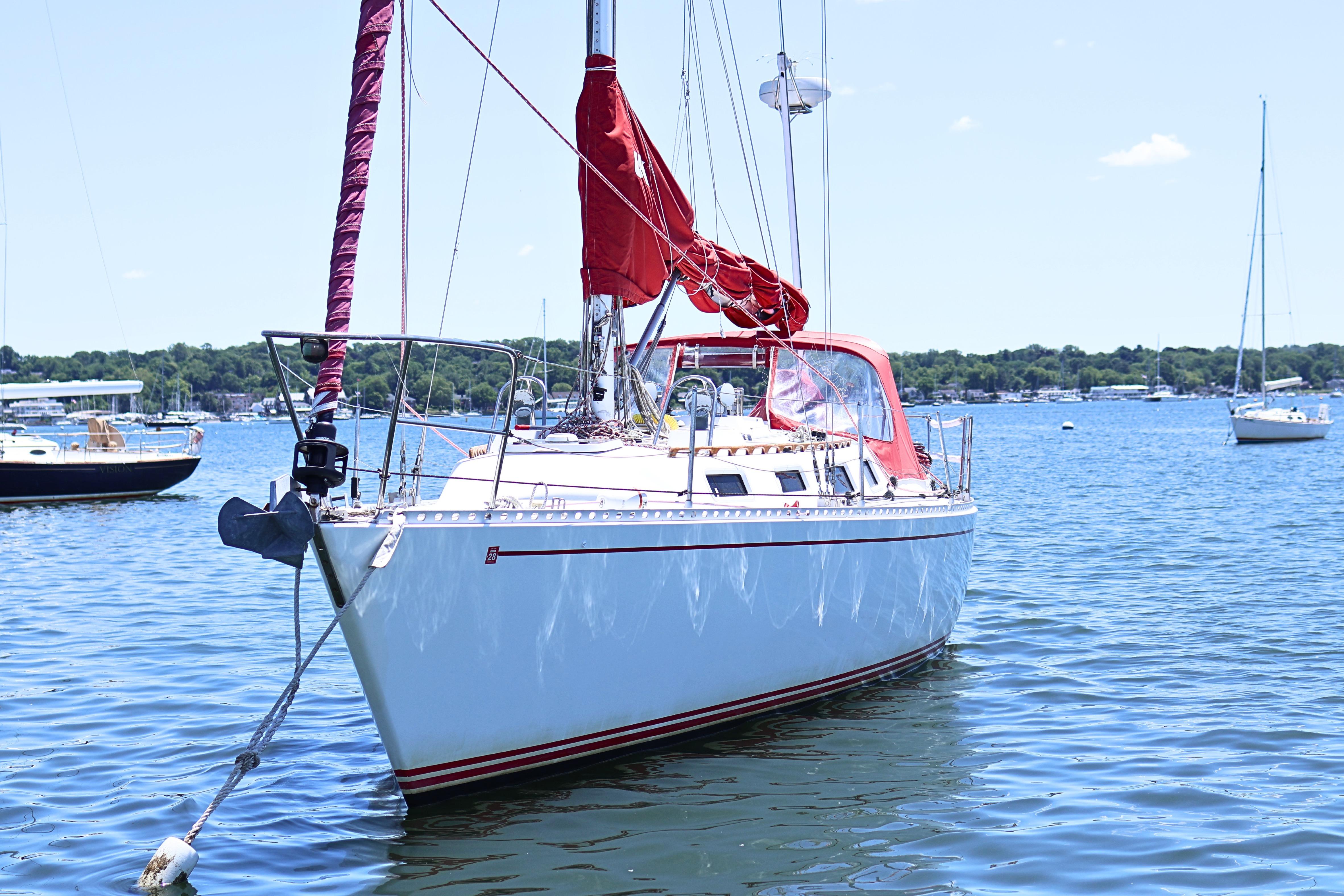 1989 J Boat J 40 sailboat anchored on a sunny day in a serene harbor.