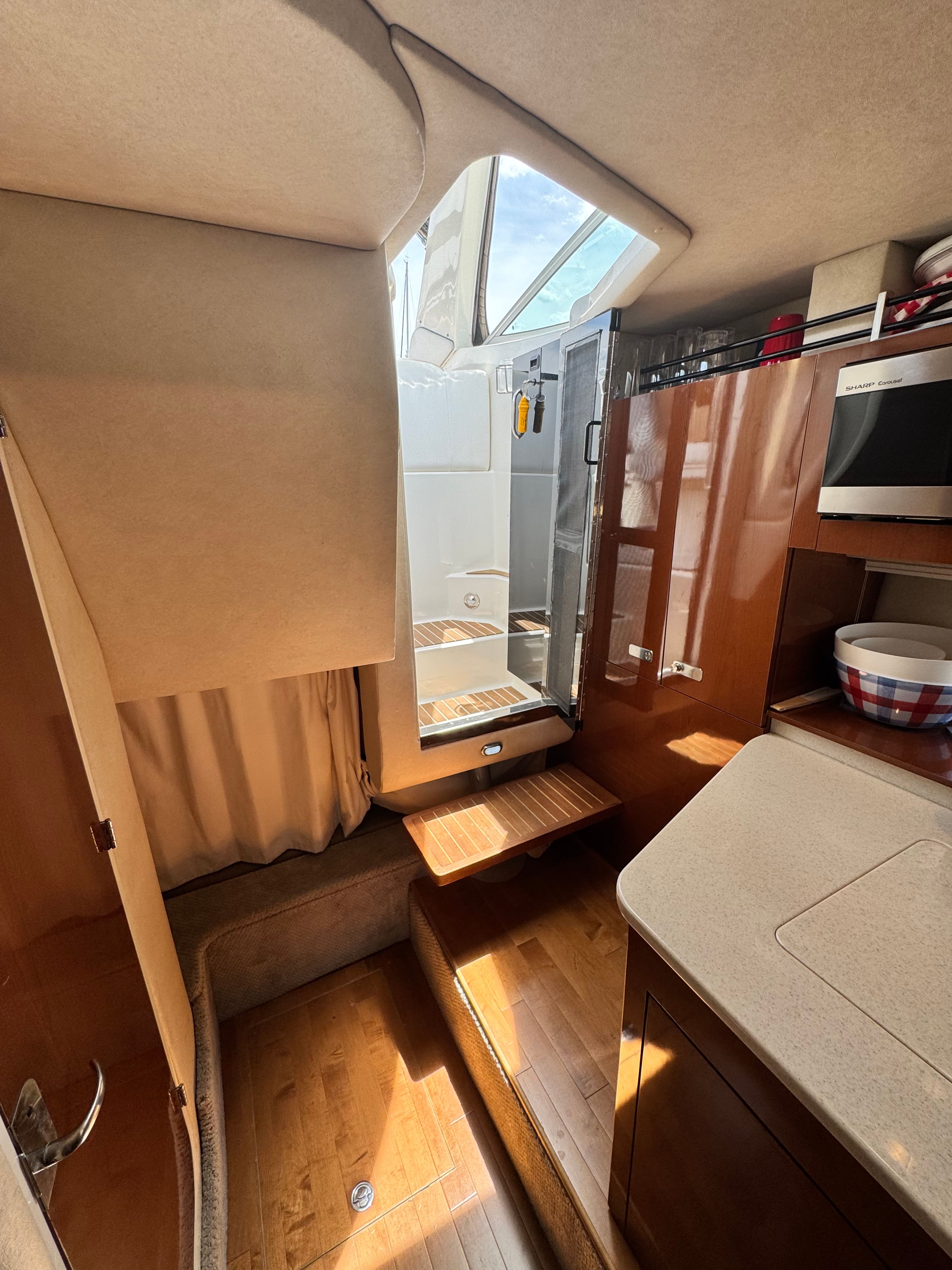 Interior of the 2010 Sea Ray Sundancer 310 with wooden flooring and modern amenities.