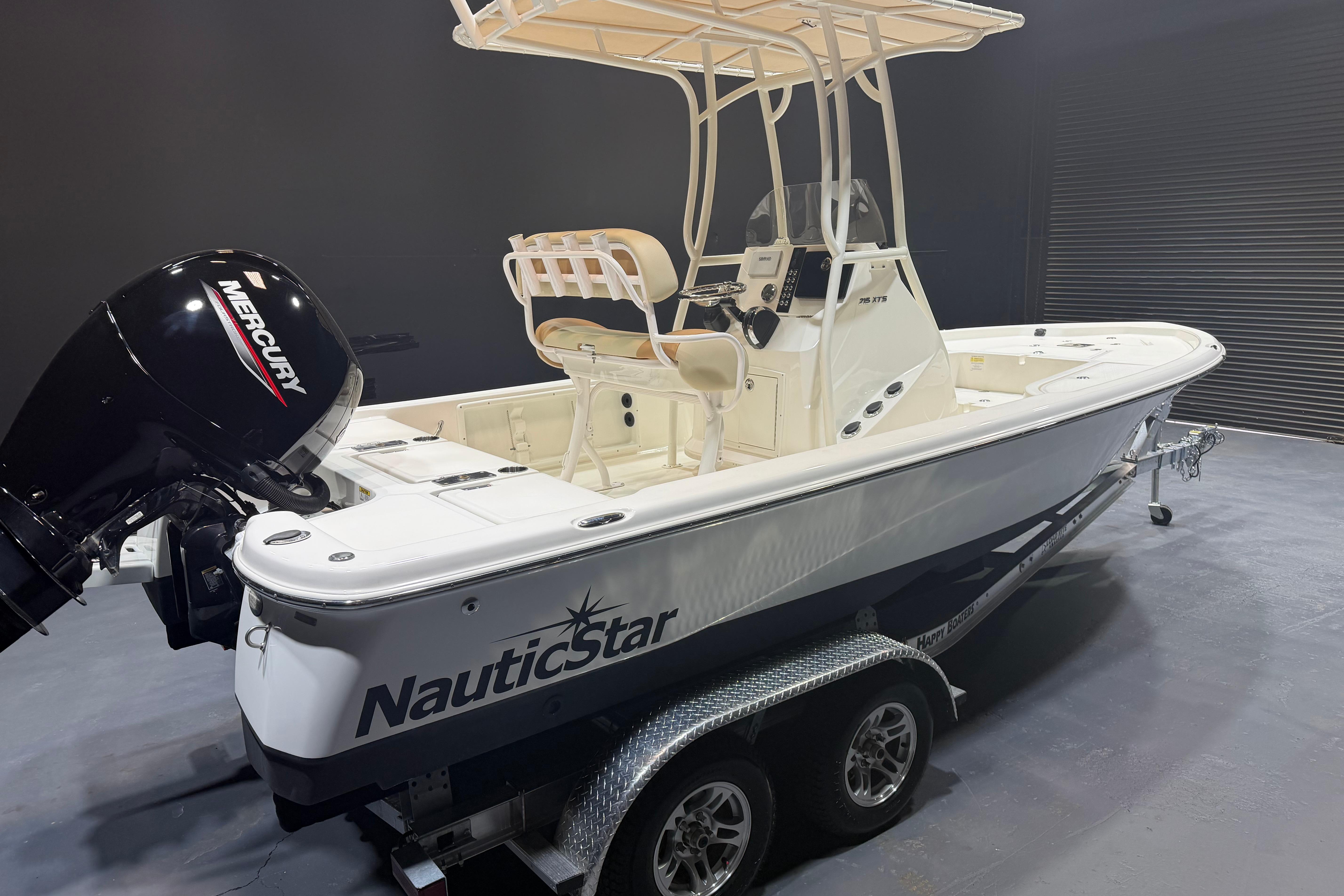 2023 NauticStar 215 XTS boat with Mercury engine on trailer in showroom.