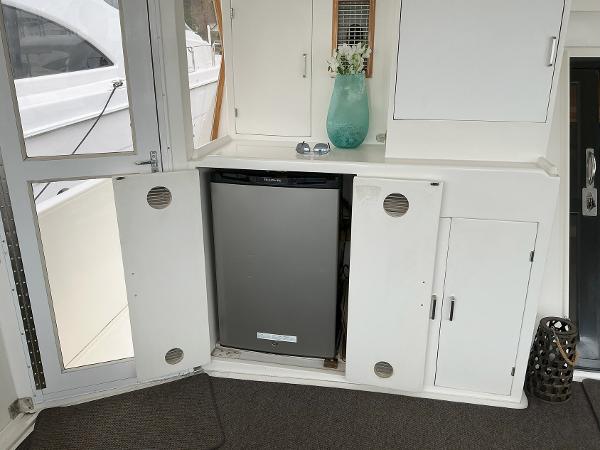 Novatec Islander 55 yacht interior with open cabinet and mini fridge, featuring modern decor.