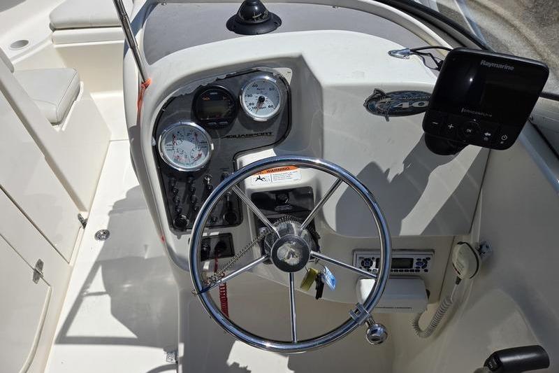 2004 Aquasport 215 Osprey Sport boat dashboard with steering wheel and gauges.