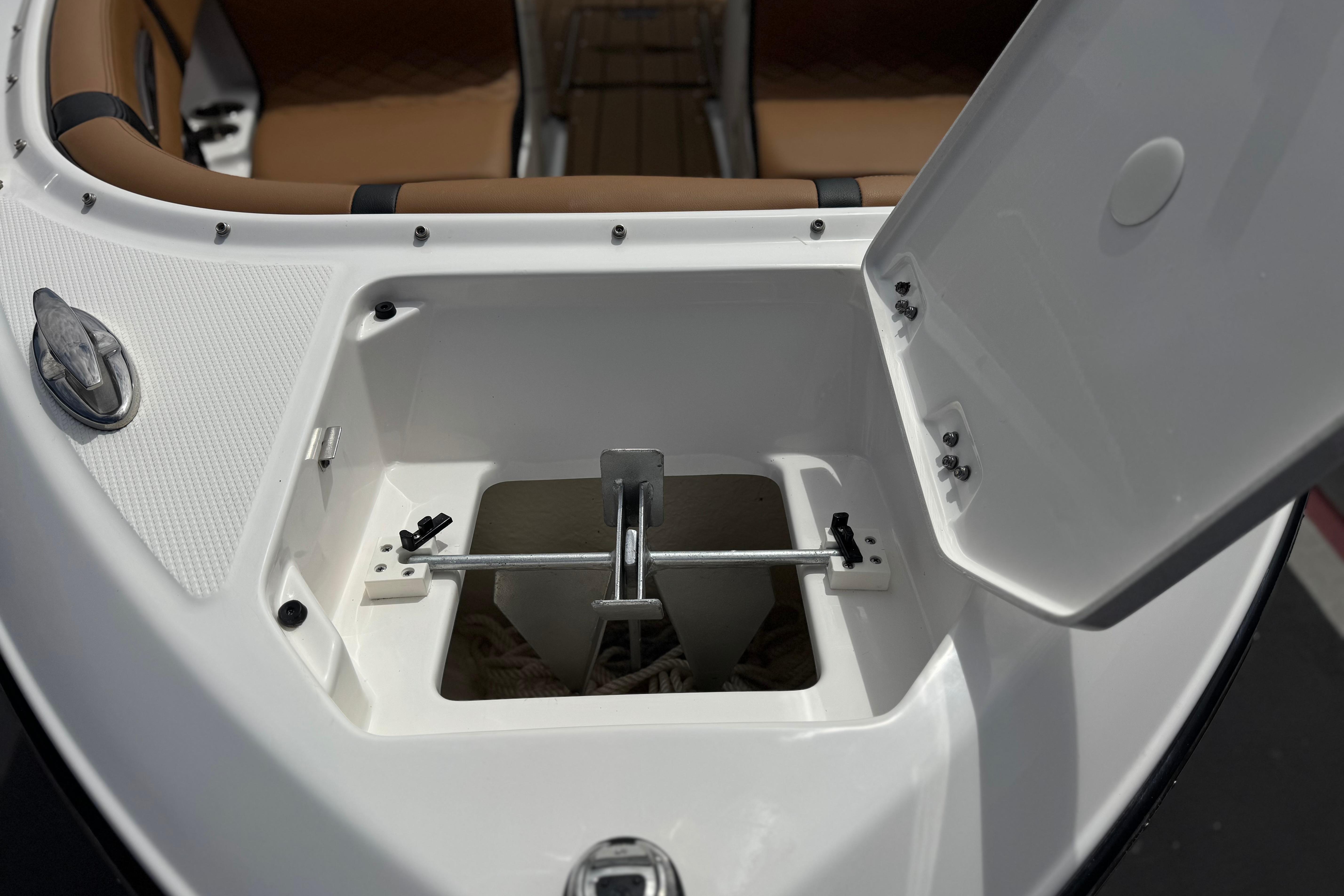 2024 Chaparral 247 SSX boat anchor compartment with open hatch, showcasing storage space.