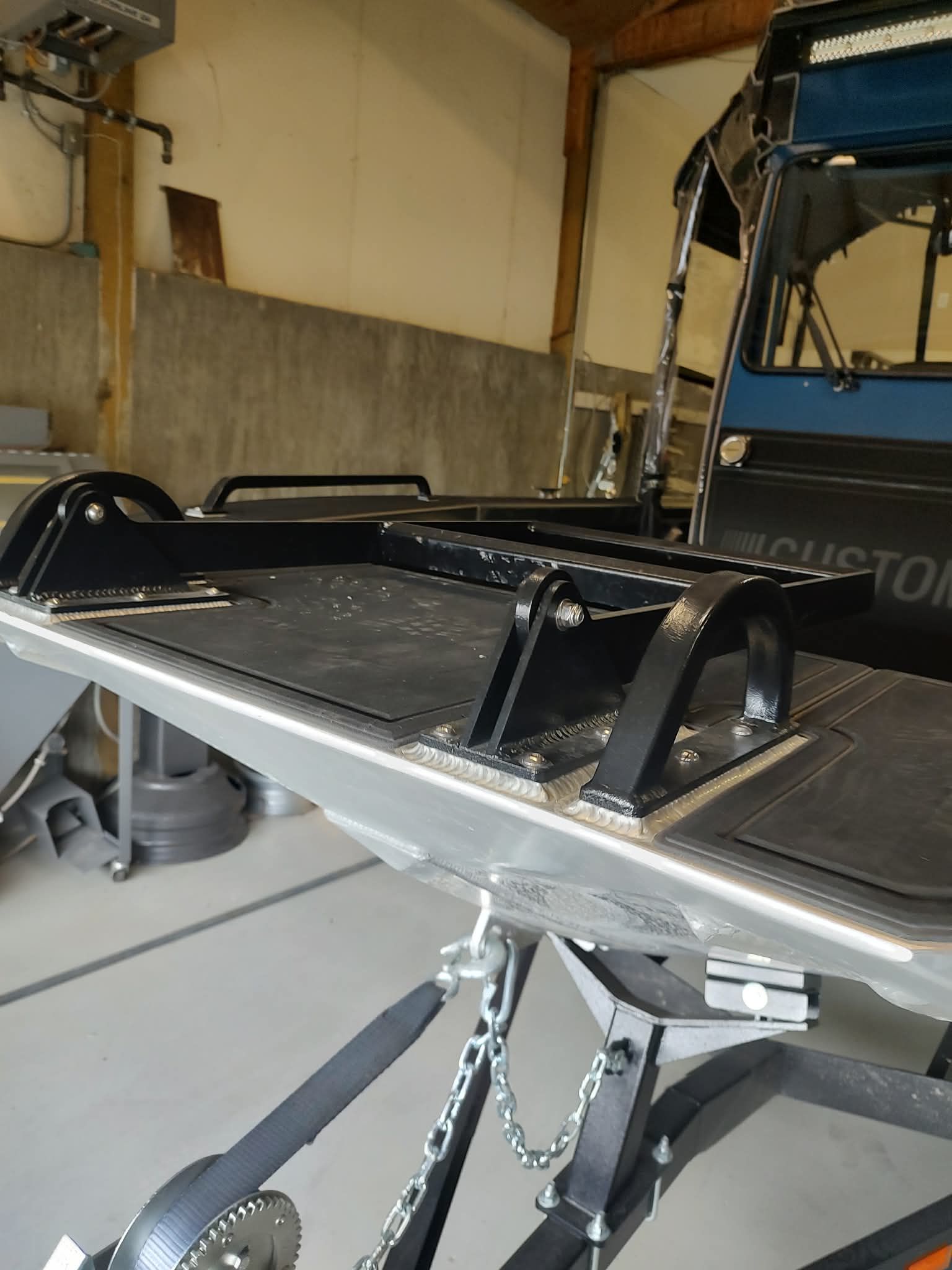 Close-up of a boat trailer with a sturdy metal frame in a garage.