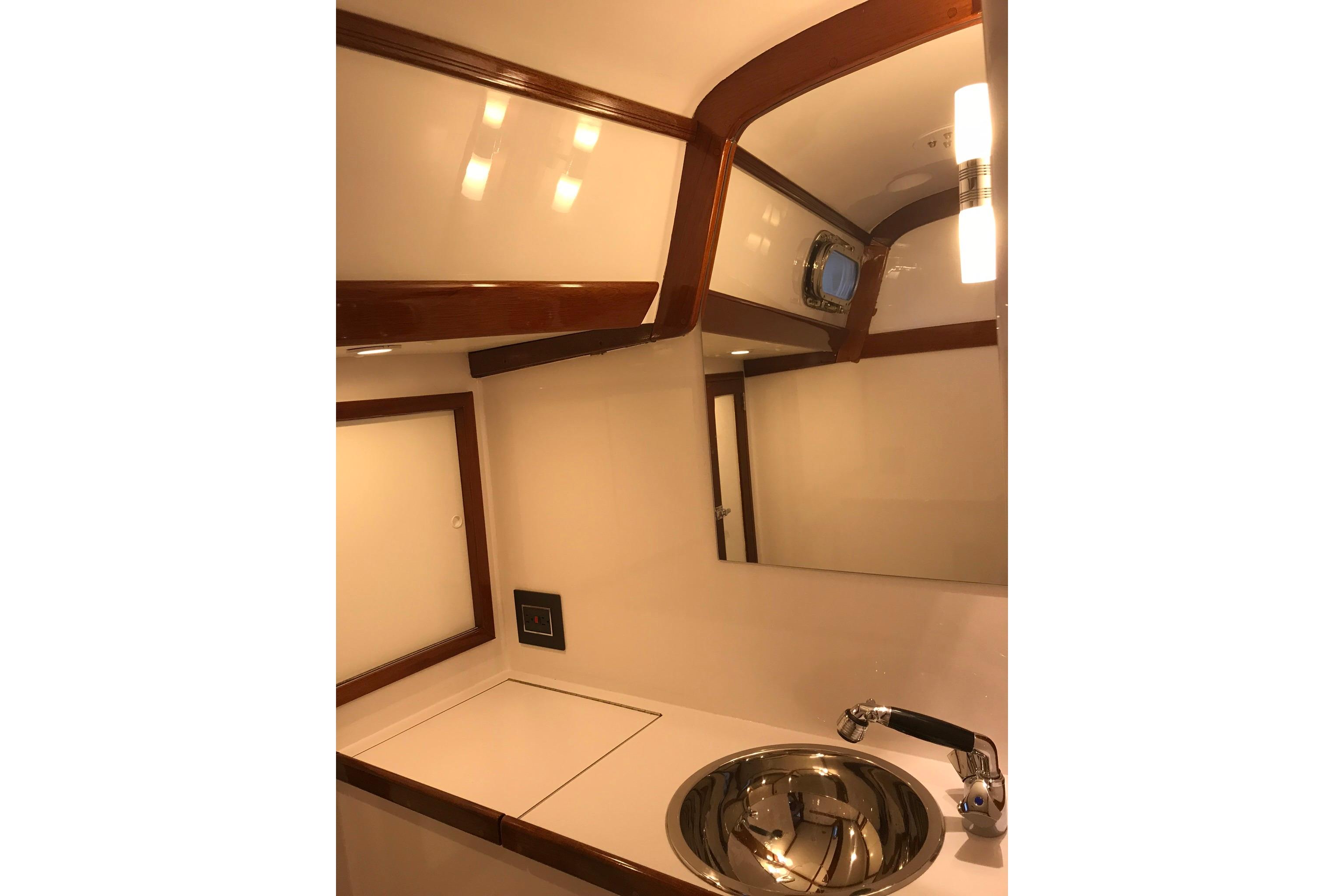 Hinckley Bermuda 40 yacht bathroom interior, featuring a sleek sink and elegant wood accents.