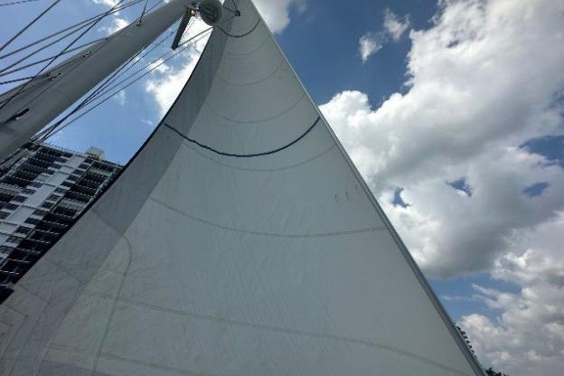 Sail of a 2010 Lagoon 421 catamaran against a cloudy sky.