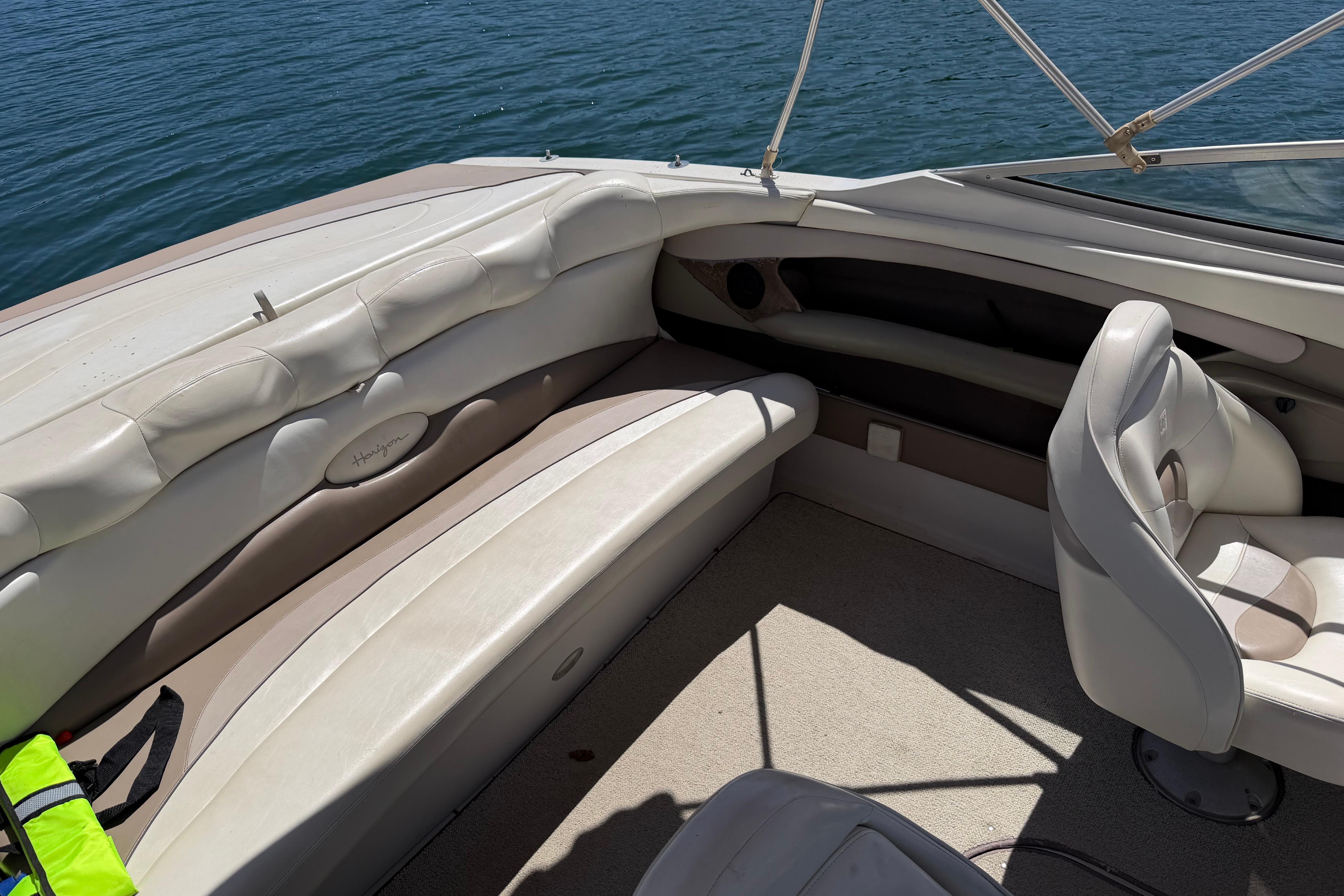 Interior of a 1998 Four Winns 220 Horizon boat with white seating and lake view.