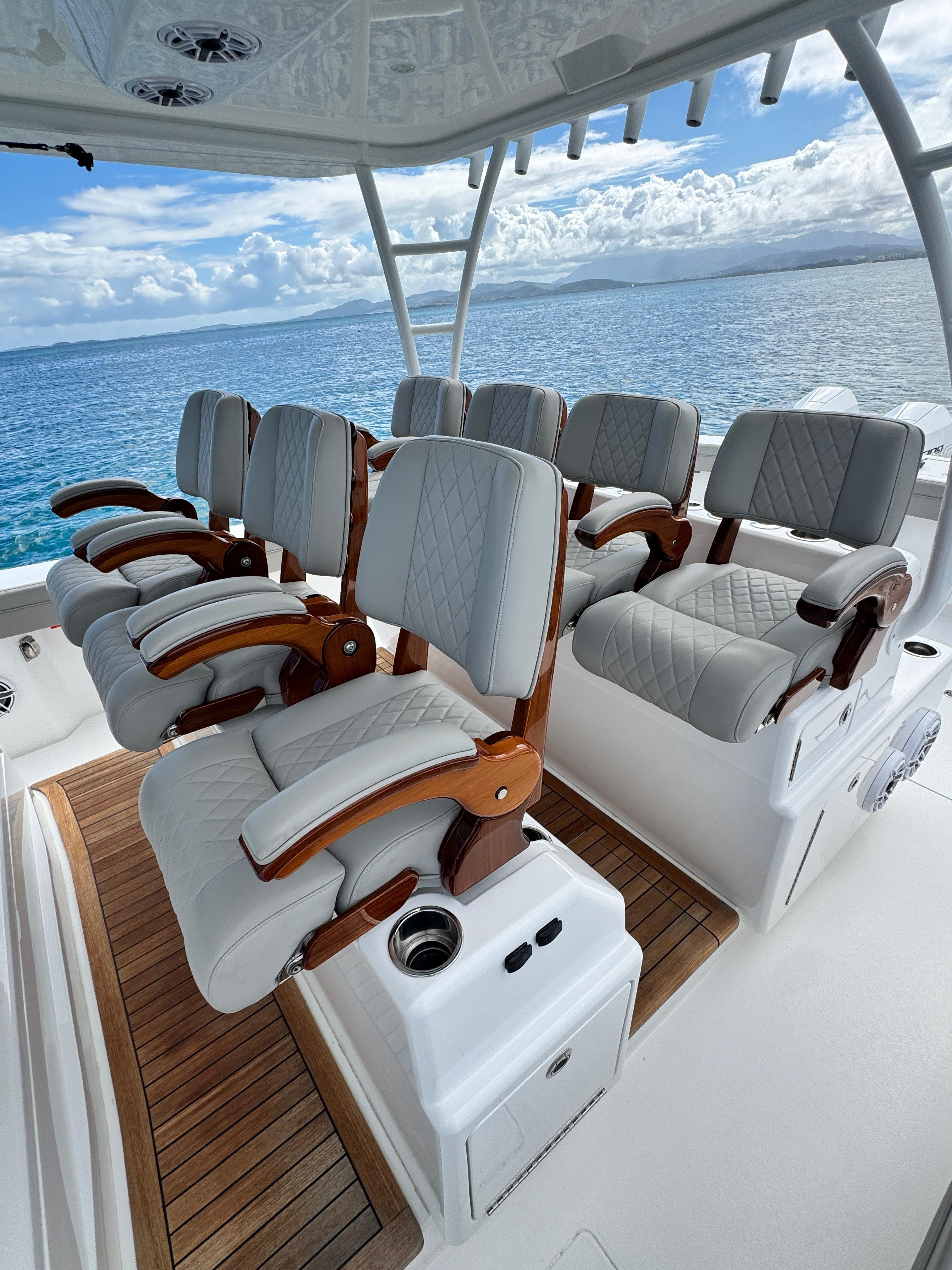 2023 Valhalla V-46 boat with luxurious seating, wooden accents, and ocean backdrop.