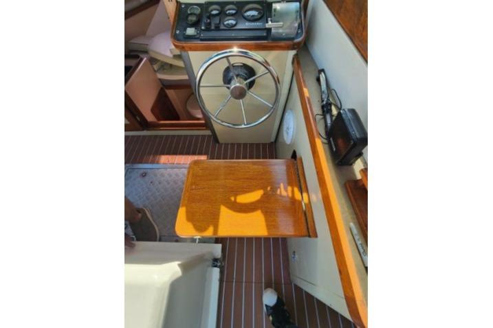 1985 Wasque Down East Cruiser helm with wooden accents and classic steering wheel.
