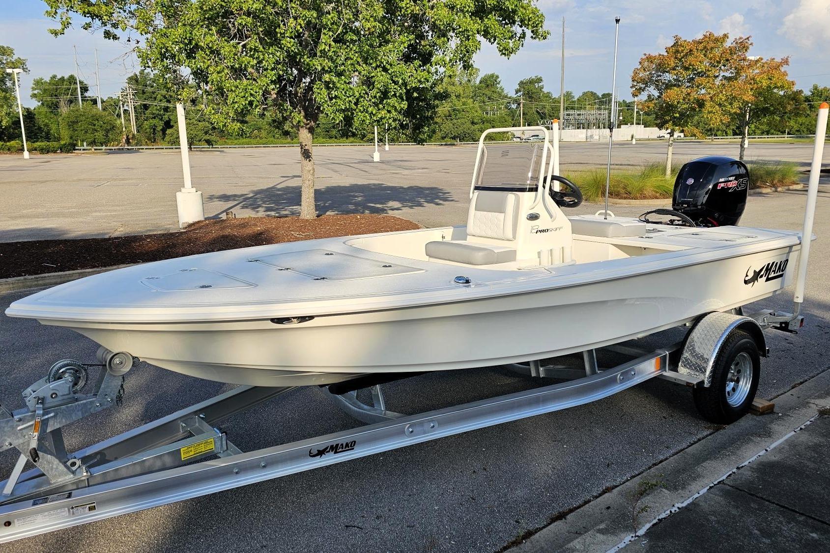 2026 Mako 18 Pro Skiff boat on trailer in parking lot, sunny day.