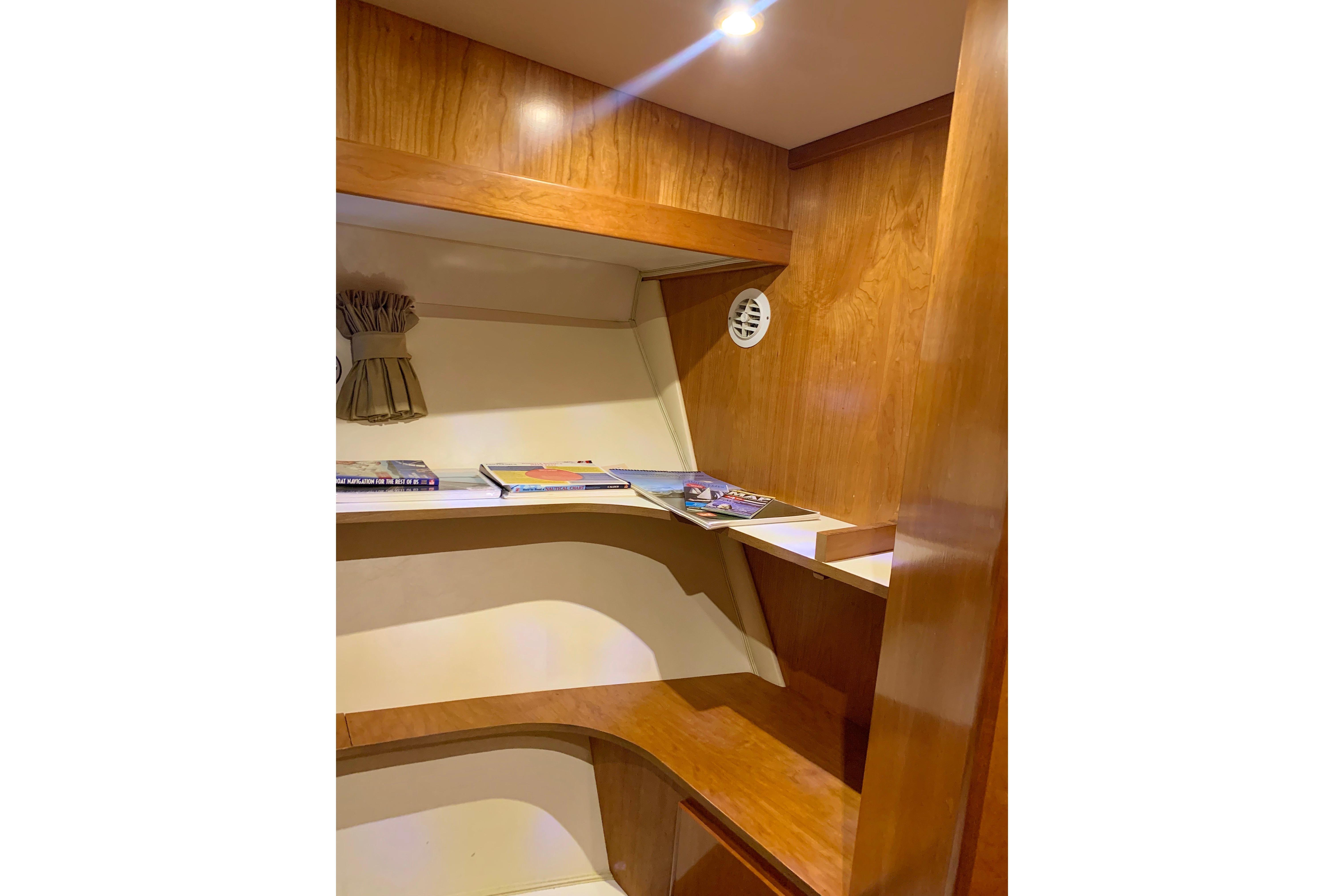 Wooden interior of 2007 Navigator 5100 yacht with shelves and books.