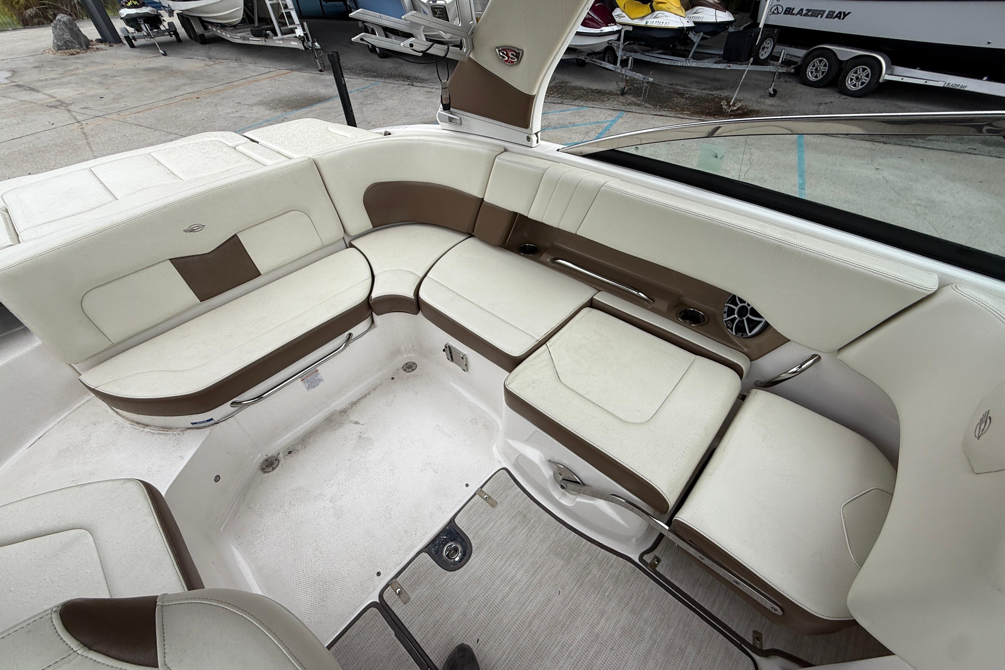 2018 Chaparral 227 SSX Surf boat interior with white and brown seating.