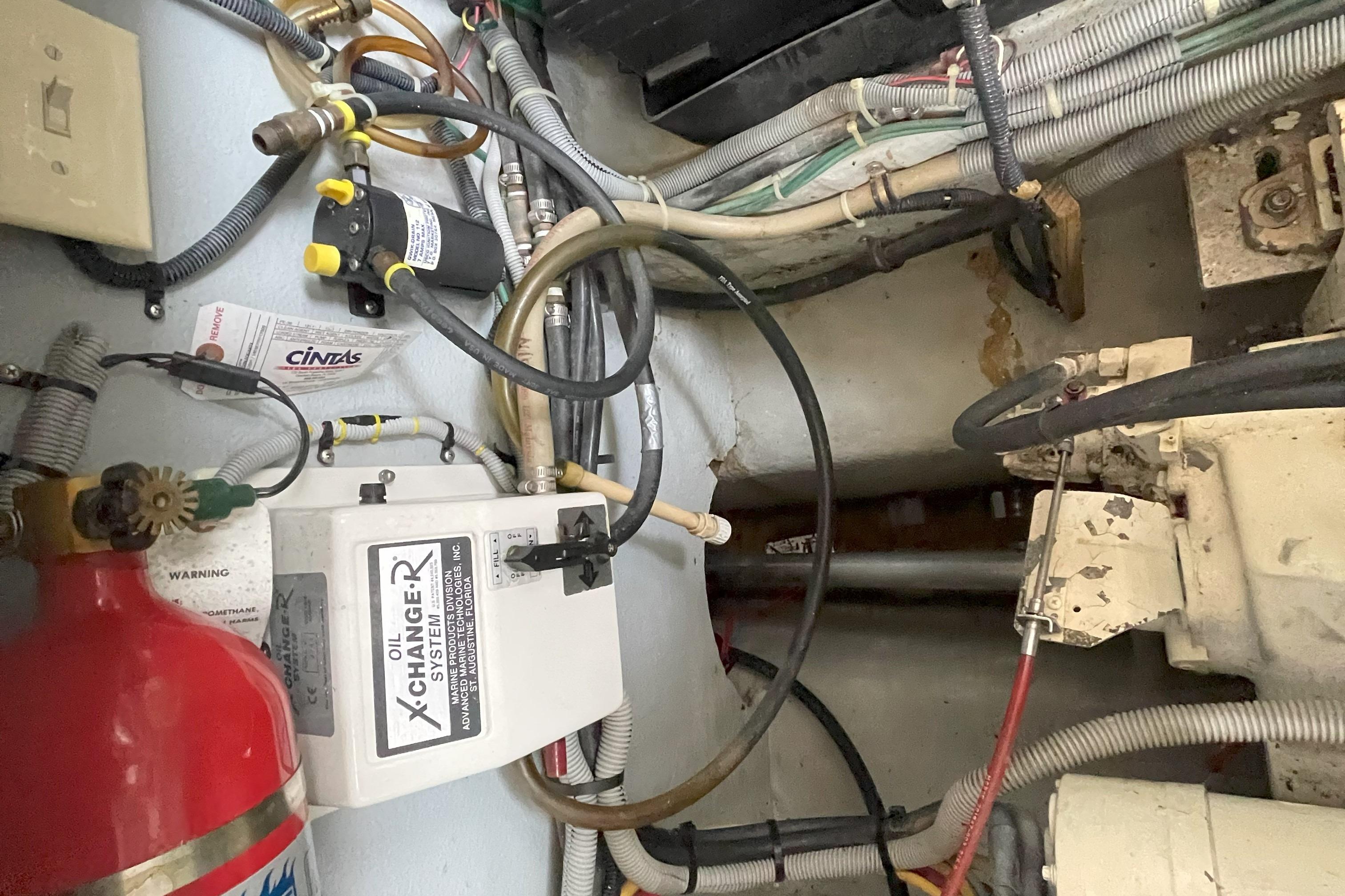 Engine room of 2000 Mainship 390 Trawler with oil change system and fire extinguisher.