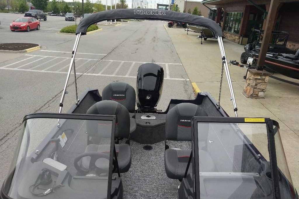 2026 Tracker Pro Guide V-16 WT boat in parking lot, featuring dual consoles and seating.