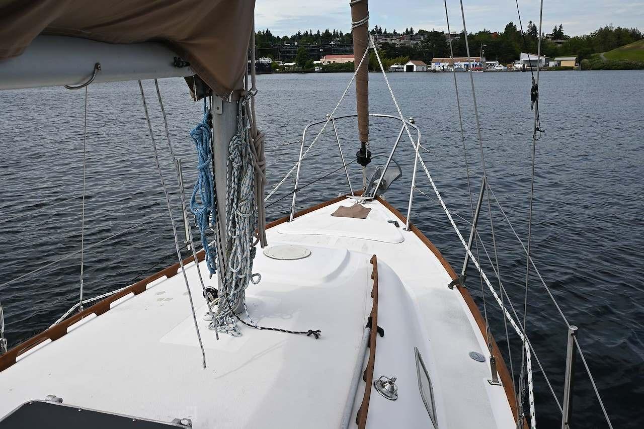 1977 Mercator Offshore sailboat deck with ropes and mast on calm water.