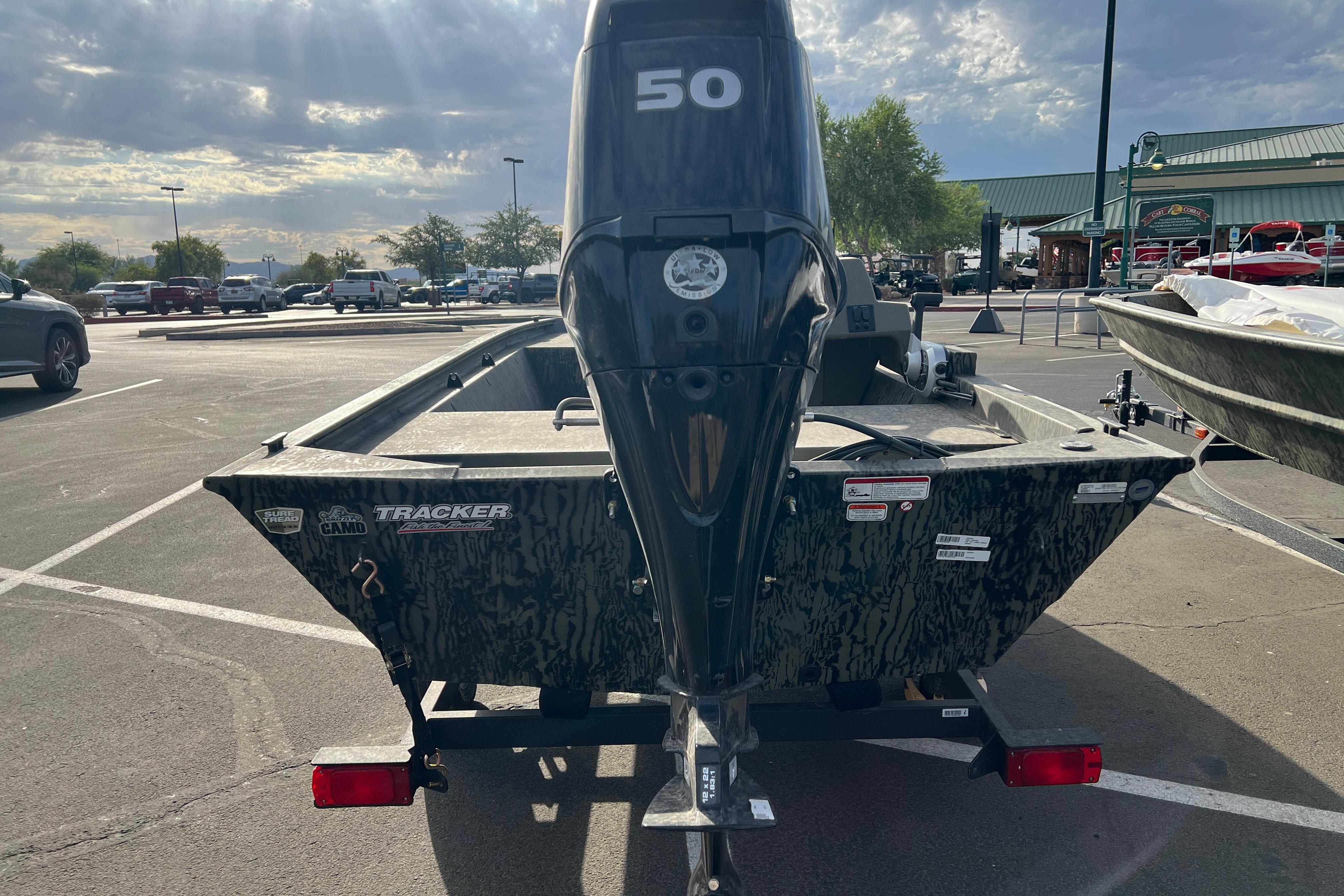 2026 Tracker Grizzly 1648 SC boat with 50 HP motor in parking lot.