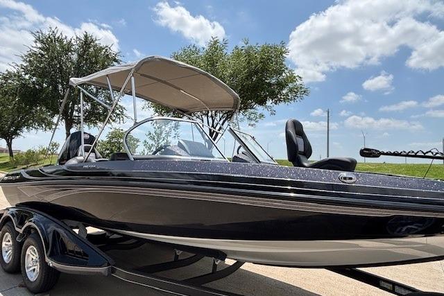 2026 Ranger 212LS boat with canopy on trailer, parked outdoors under blue sky.