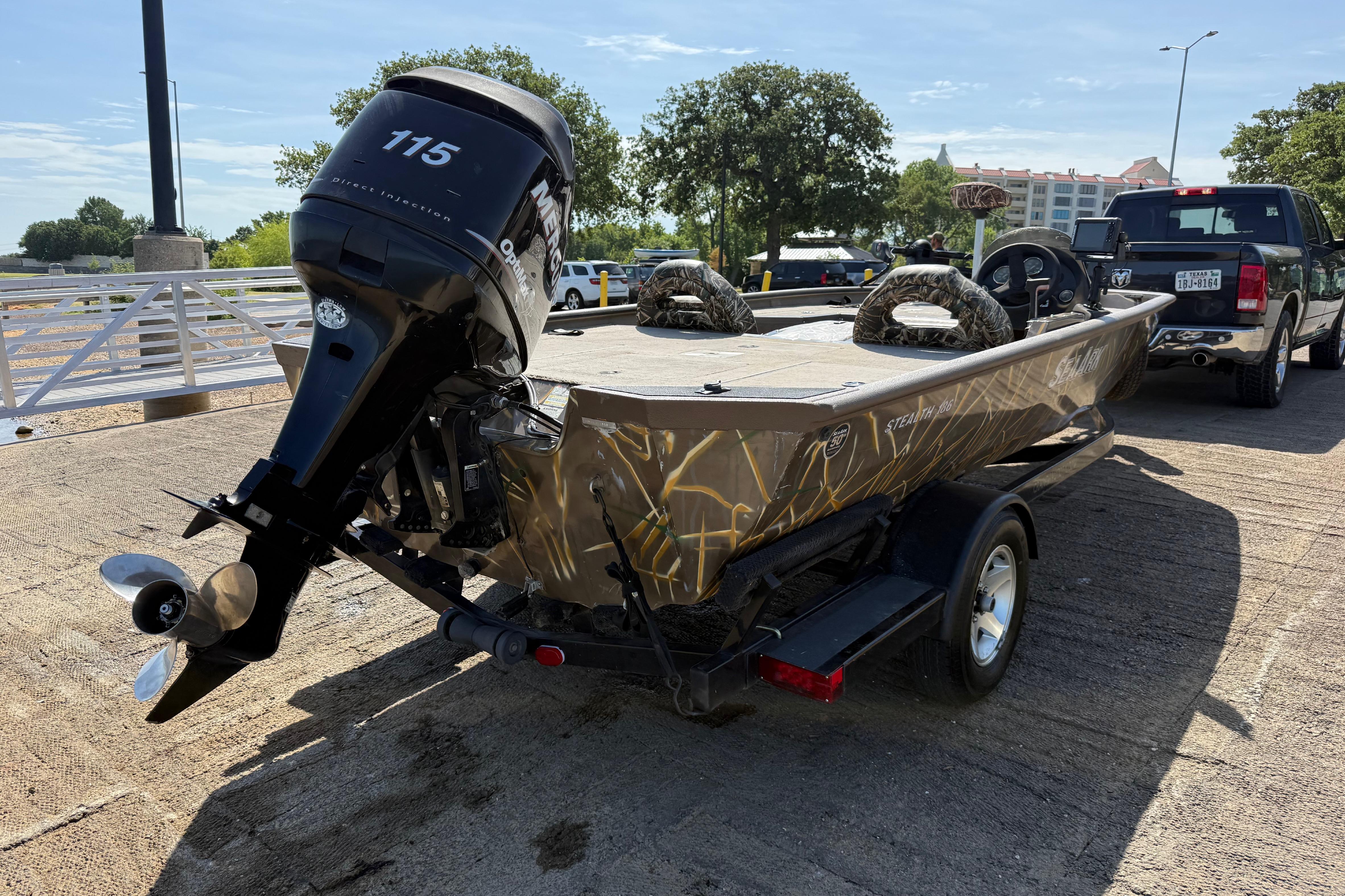 2010 SeaArk Stealth 190 boat with 115 HP motor on trailer, parked outdoors.