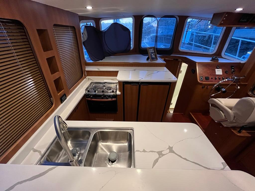 Modern kitchen interior of 2025 Bracewell 41 yacht with sleek countertops and stainless steel sink.