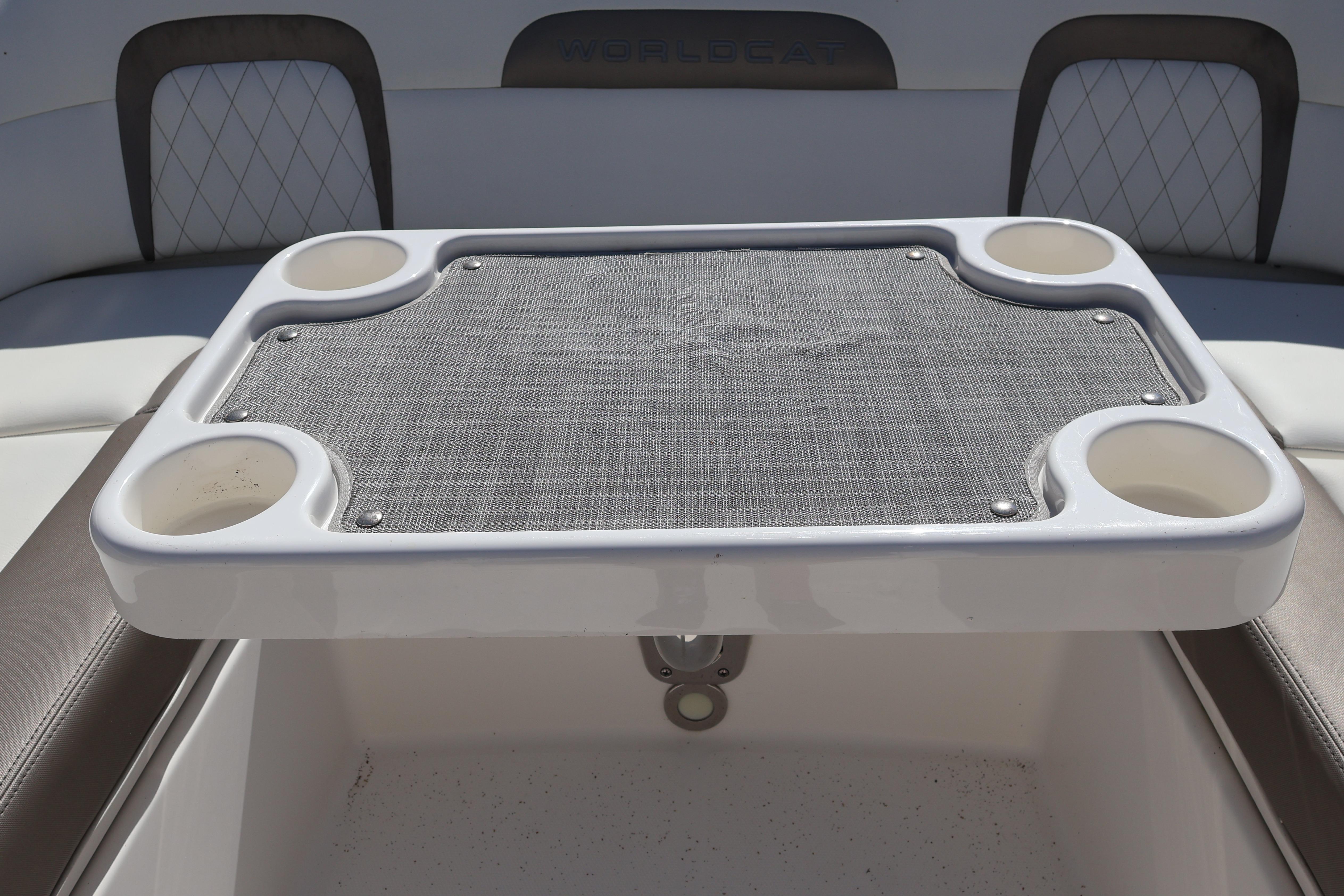 2022 World Cat 280 CC-X boat table with cup holders and mesh surface.