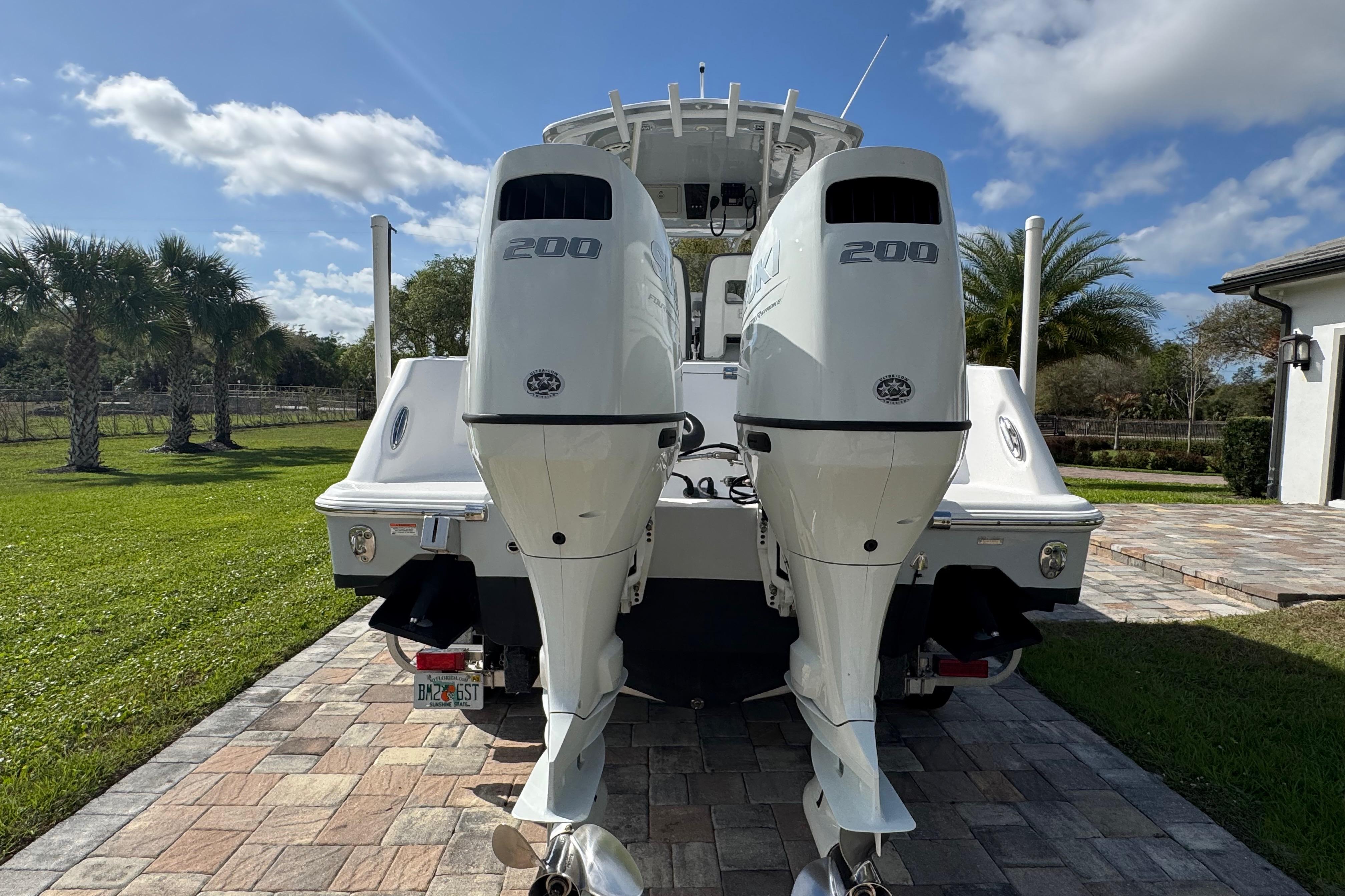 2022 Aquasport 2500 Center Console boat with dual 200 horsepower engines, parked on a driveway.