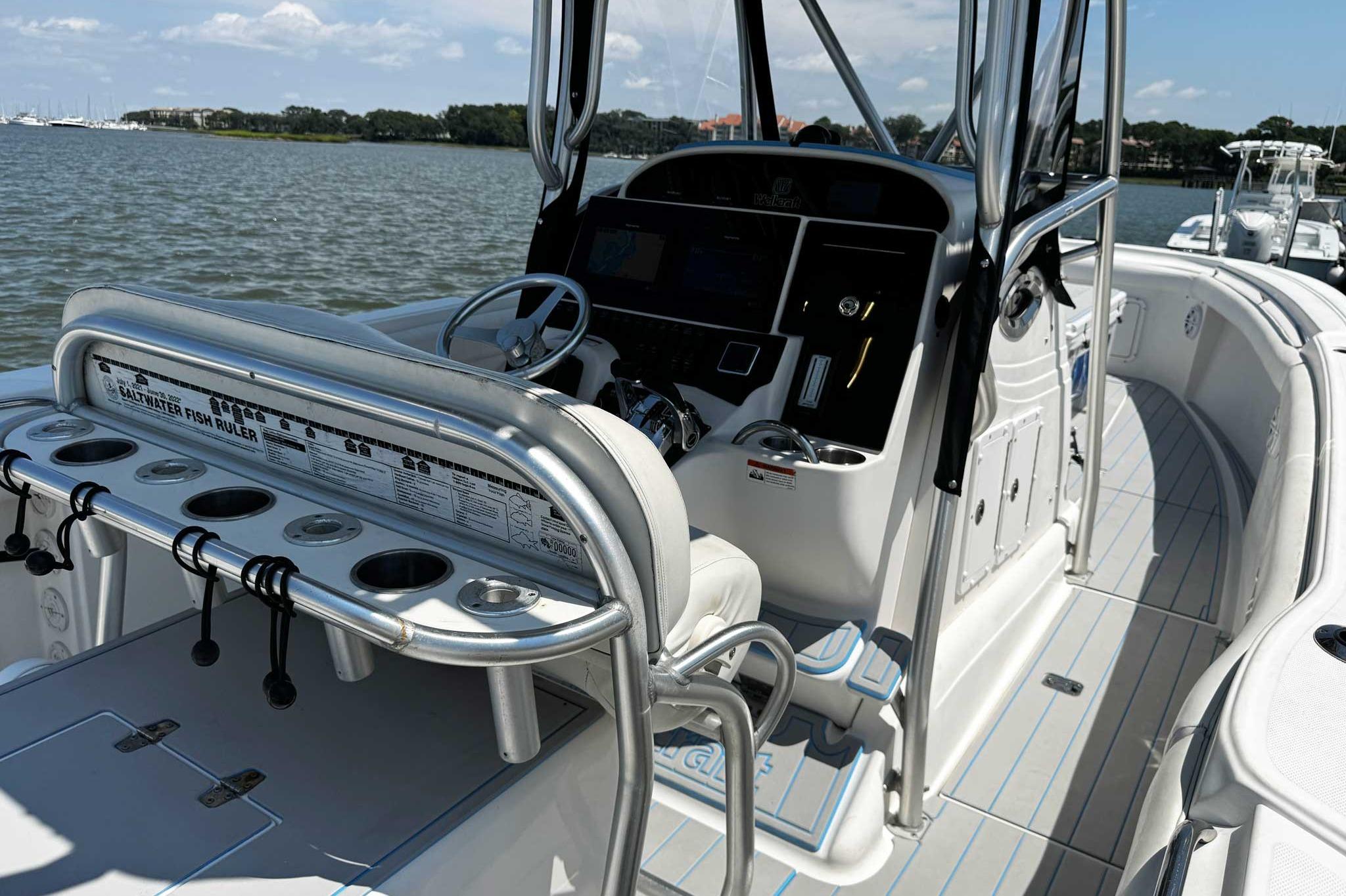 2005 Wellcraft 32 CCF boat interior with steering console and fishing rod holders.