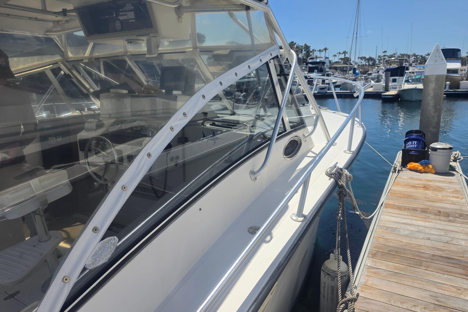 1999 Albemarle 305 Express Fisherman docked at marina, showcasing sleek design and spacious cockpit.