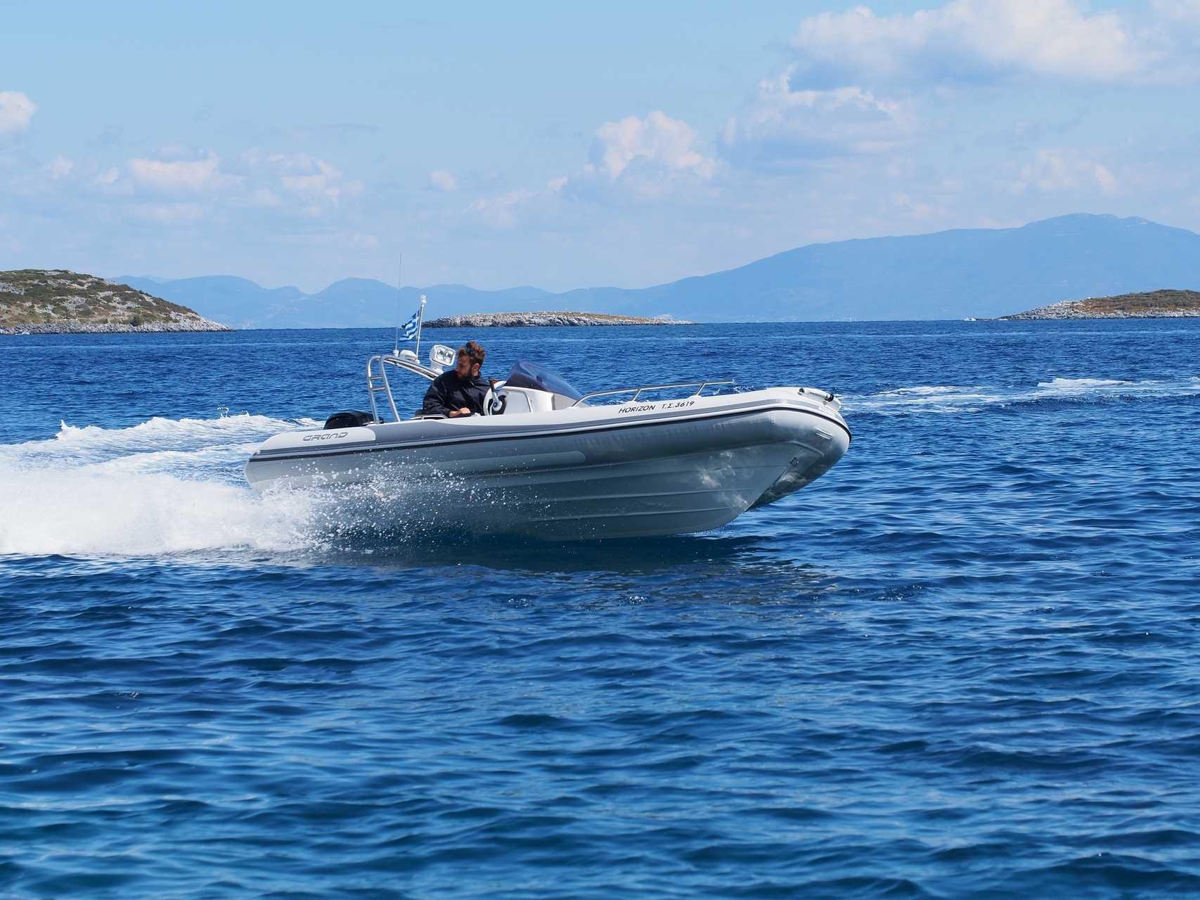 2025 Grand Inflatables G500 boat cruising on open blue sea with distant islands.