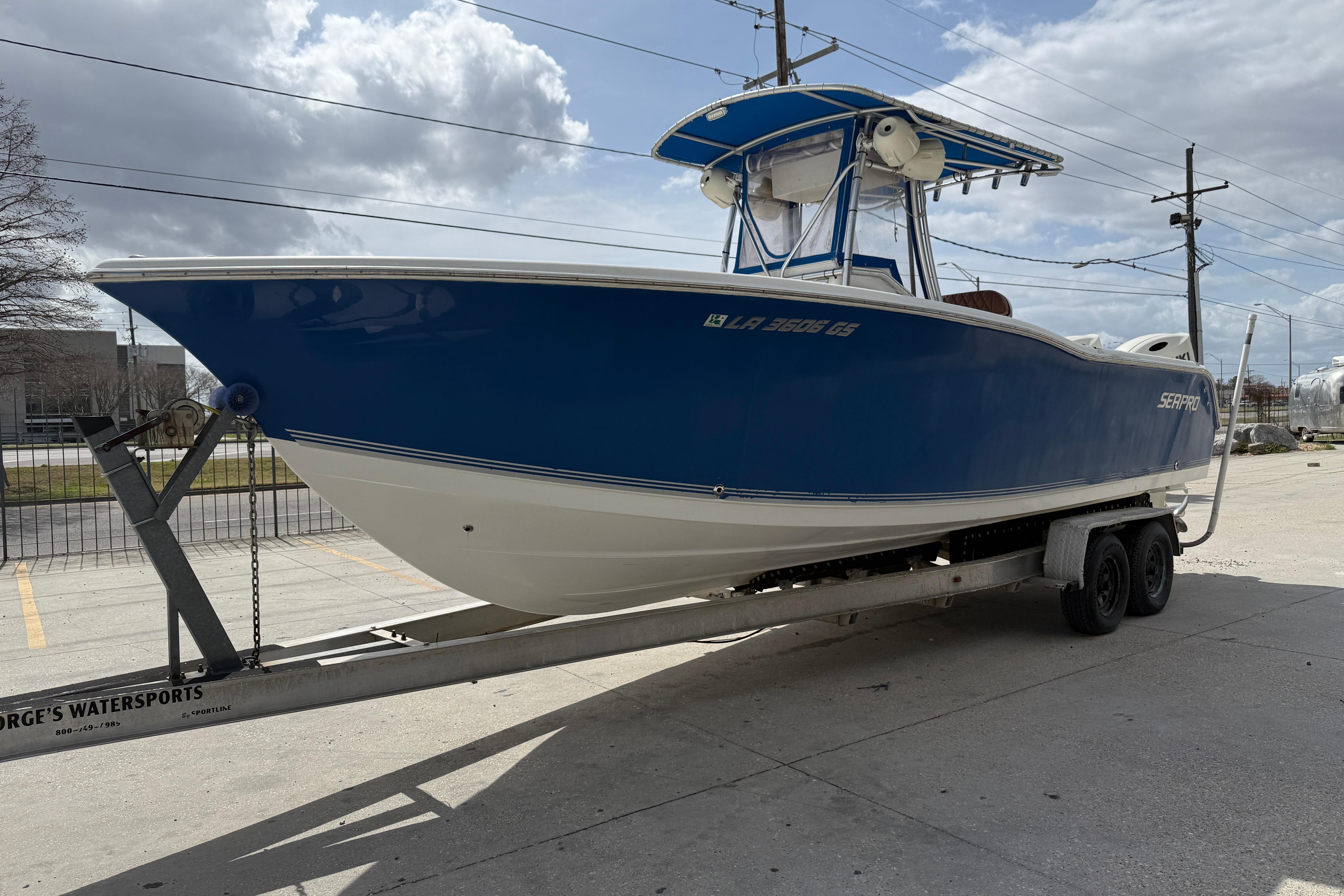 2007 Sea Pro 270 Center Console boat on trailer, blue and white design, parked outdoors.