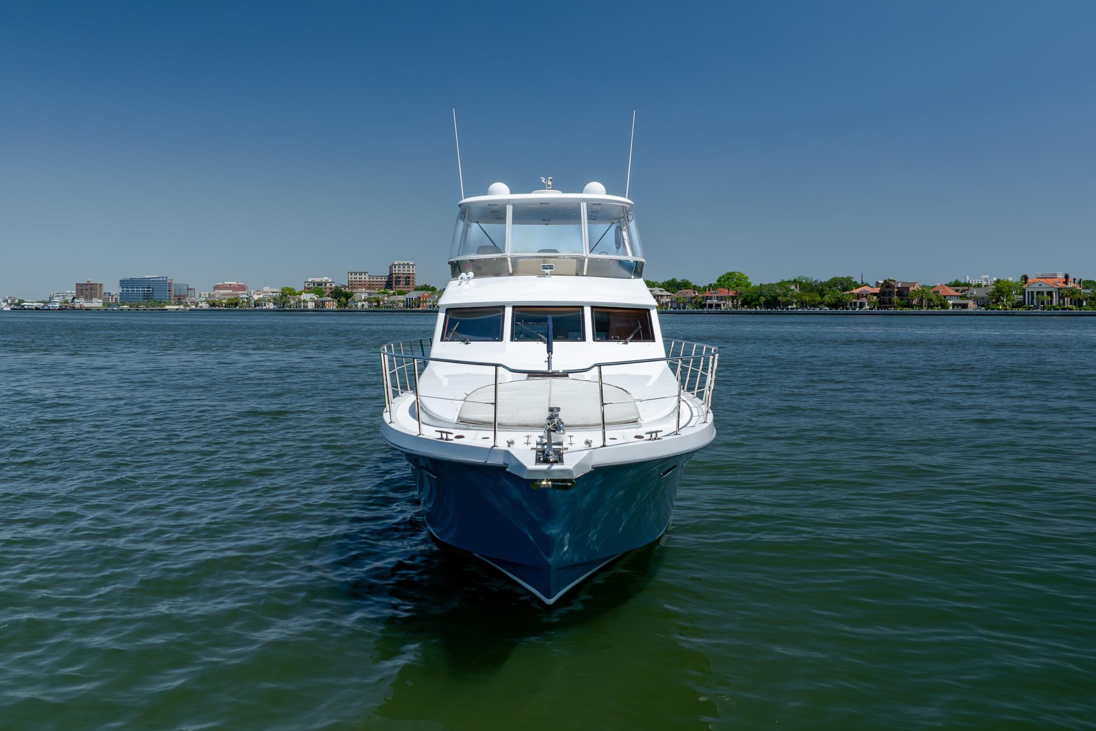 Ocean Alexander yacht on calm water with cityscape in the background.