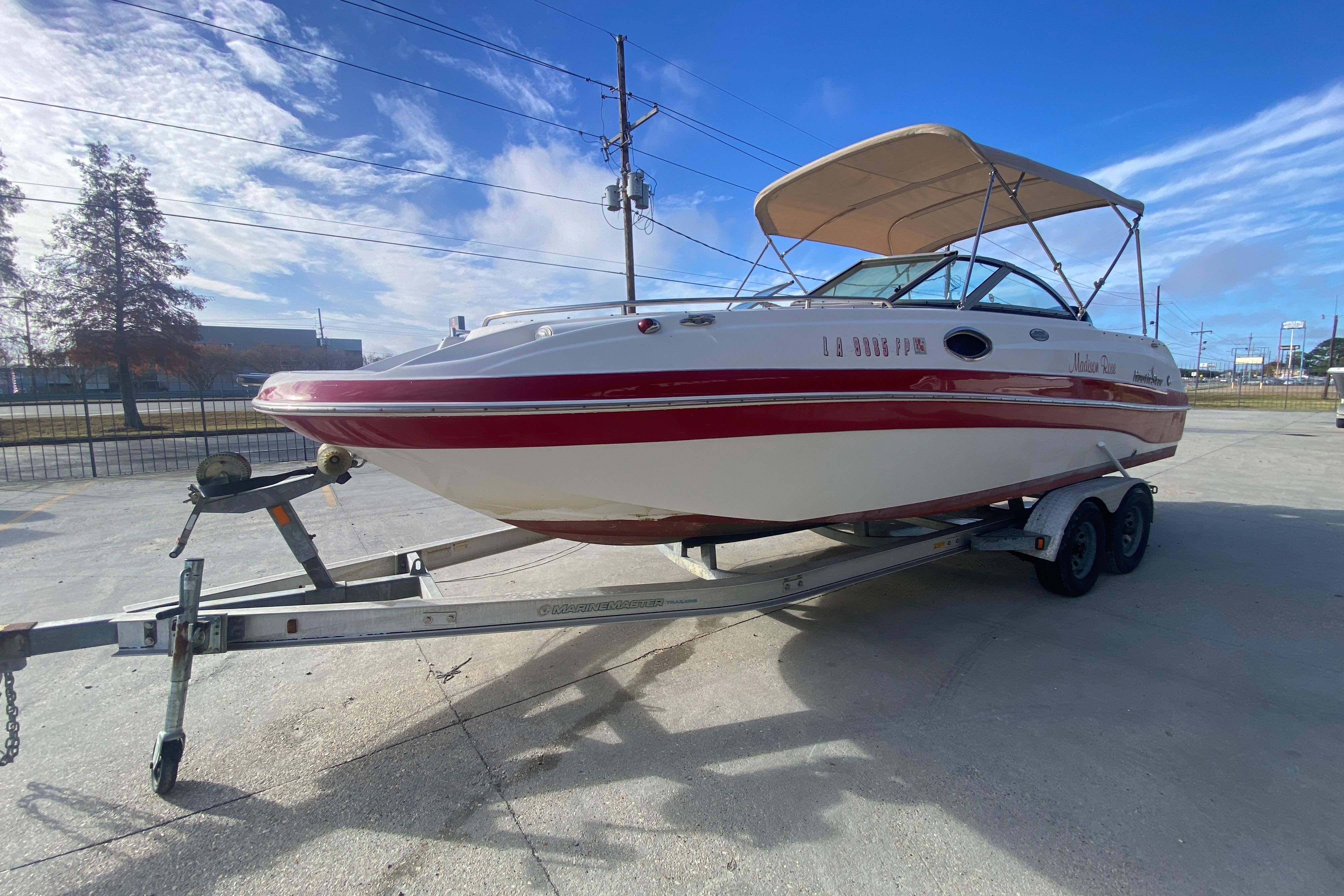 2007 NauticStar 230DC Sport Deck boat on trailer under clear blue sky.