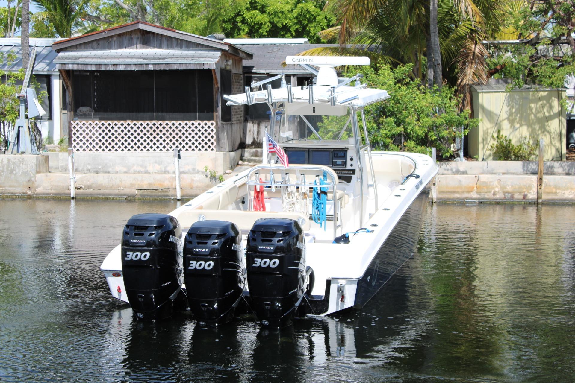 2007 Fountain 34 Center Console boat with triple 300 horsepower engines docked by a waterfront.