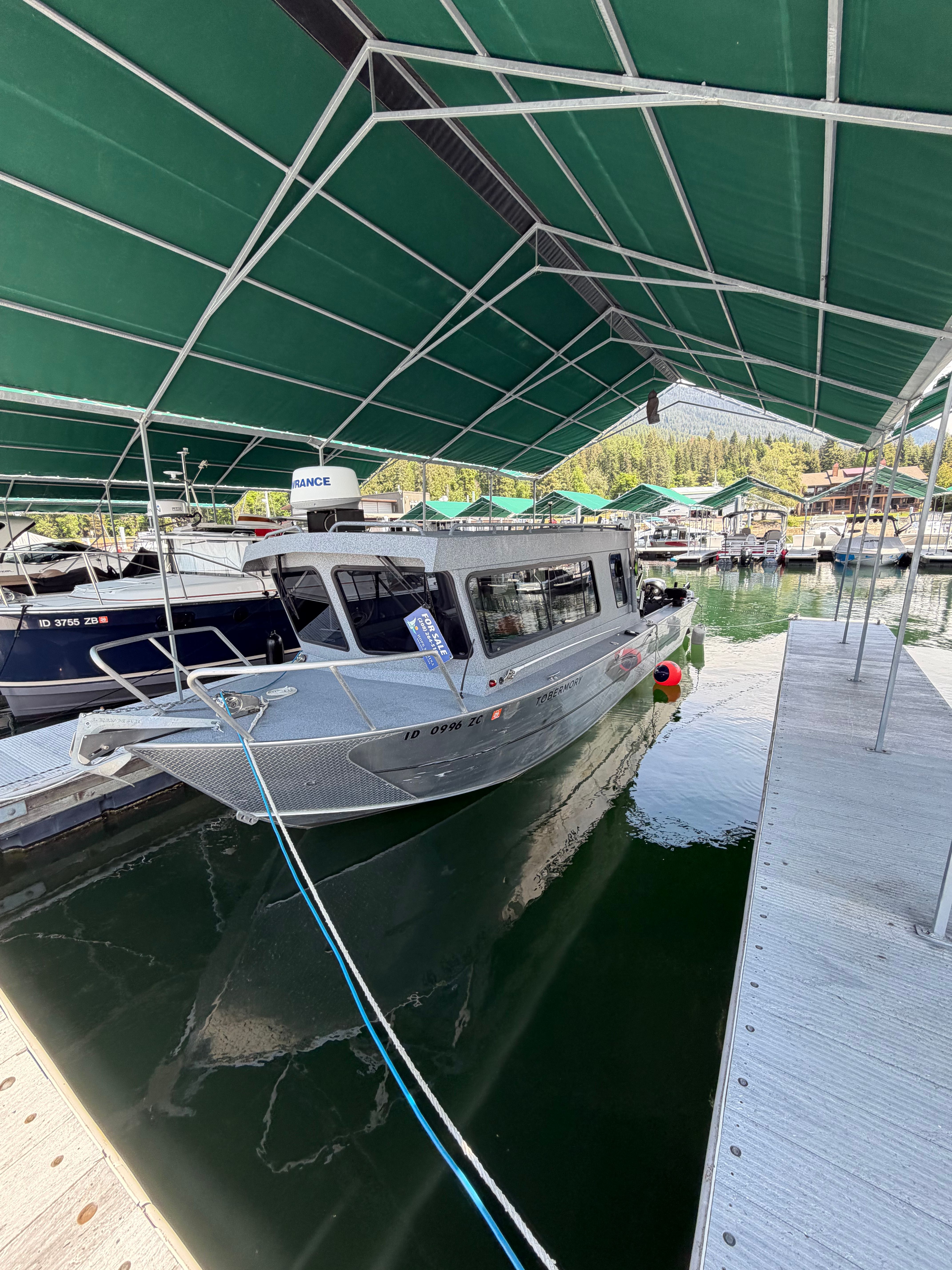 2013 Alumaweld Pacific 27 boat docked under green canopy.