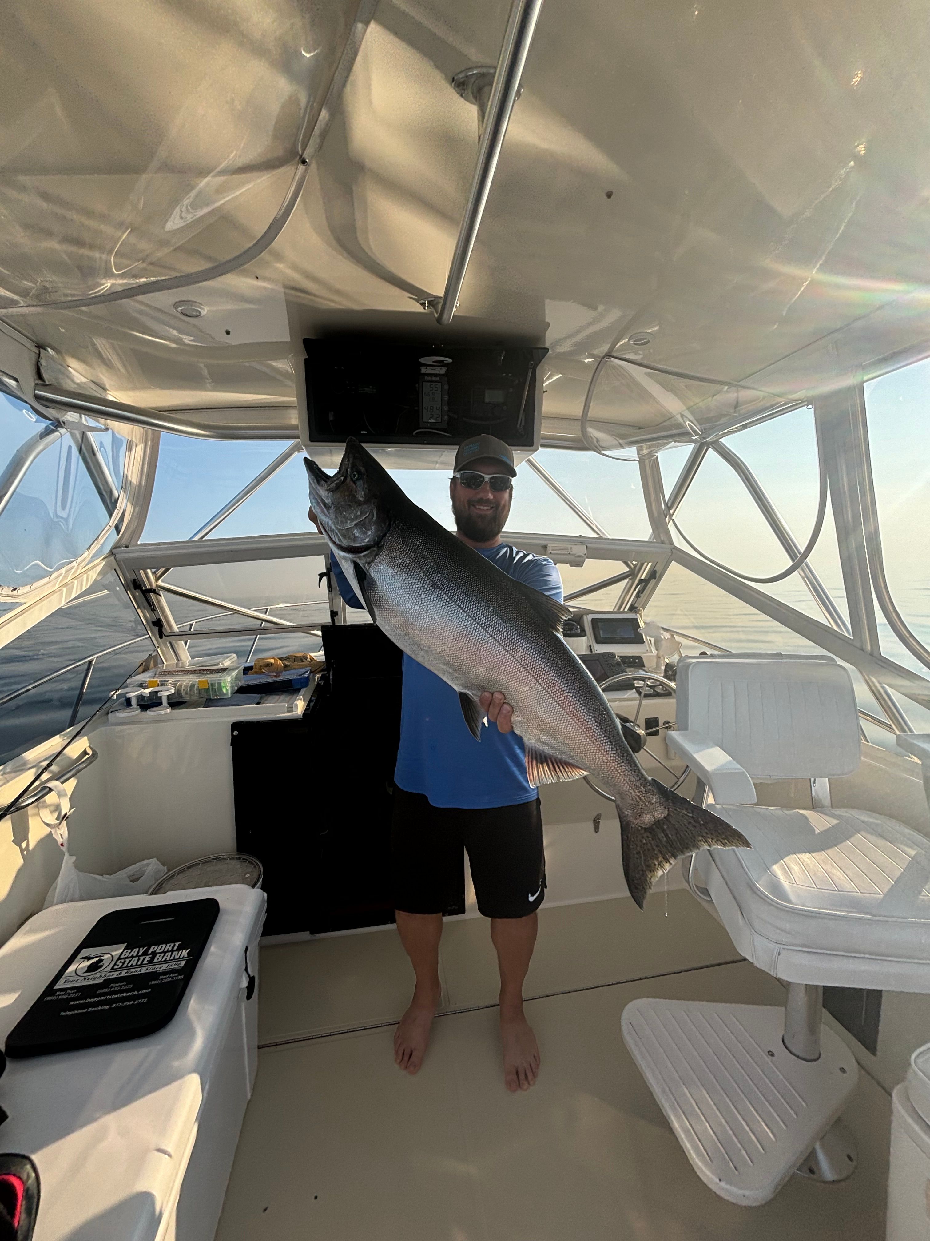 Angler holding large fish on Carolina Classic 28 Express boat, 2004.