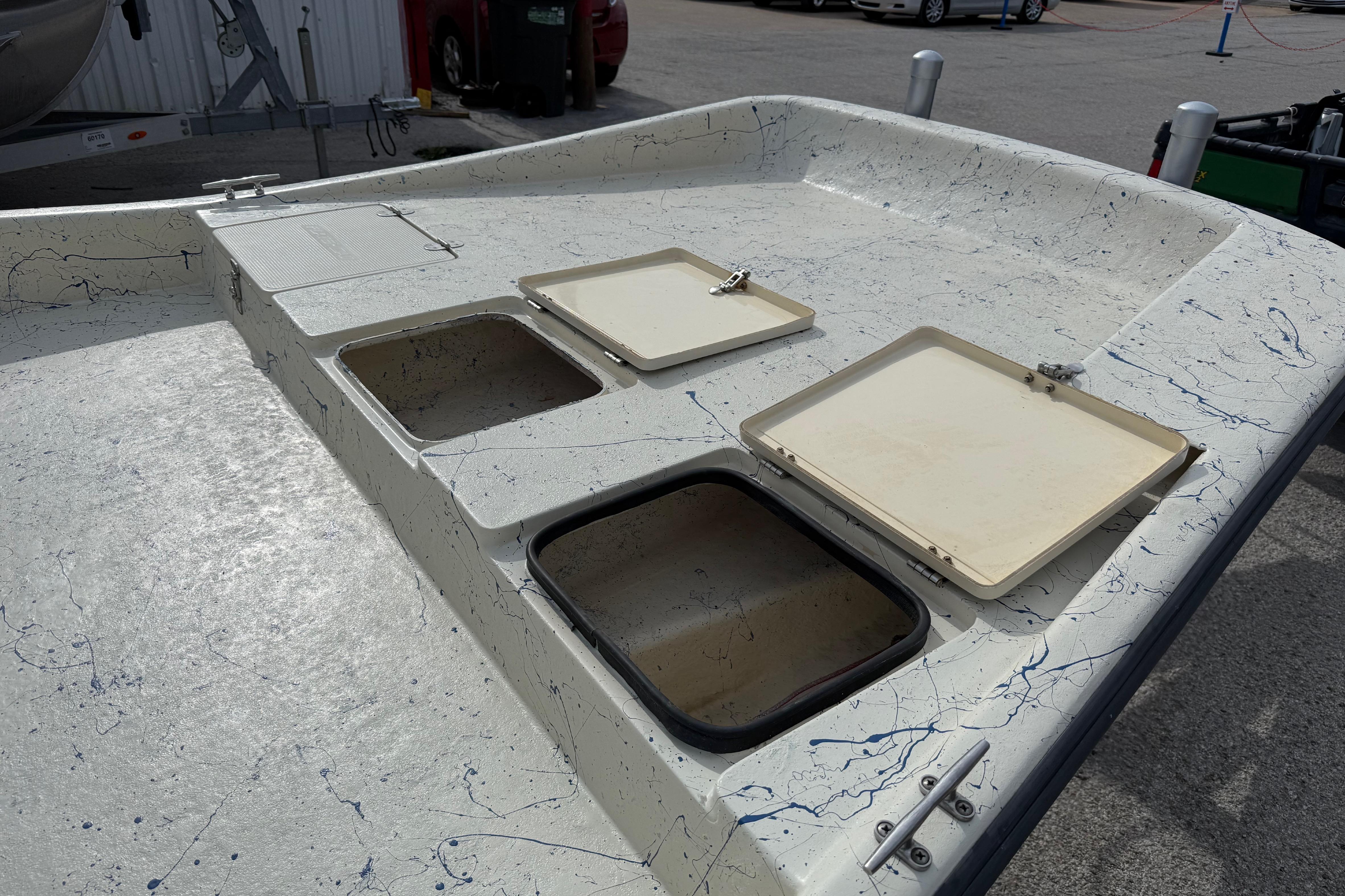 2007 Flats Cat 19 boat deck with open storage compartments and speckled design.