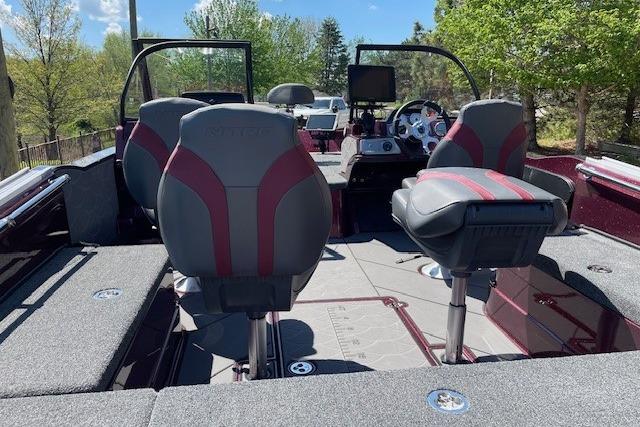 2026 Nitro ZV20 Pro boat interior with modern seating and dashboard, surrounded by lush greenery.