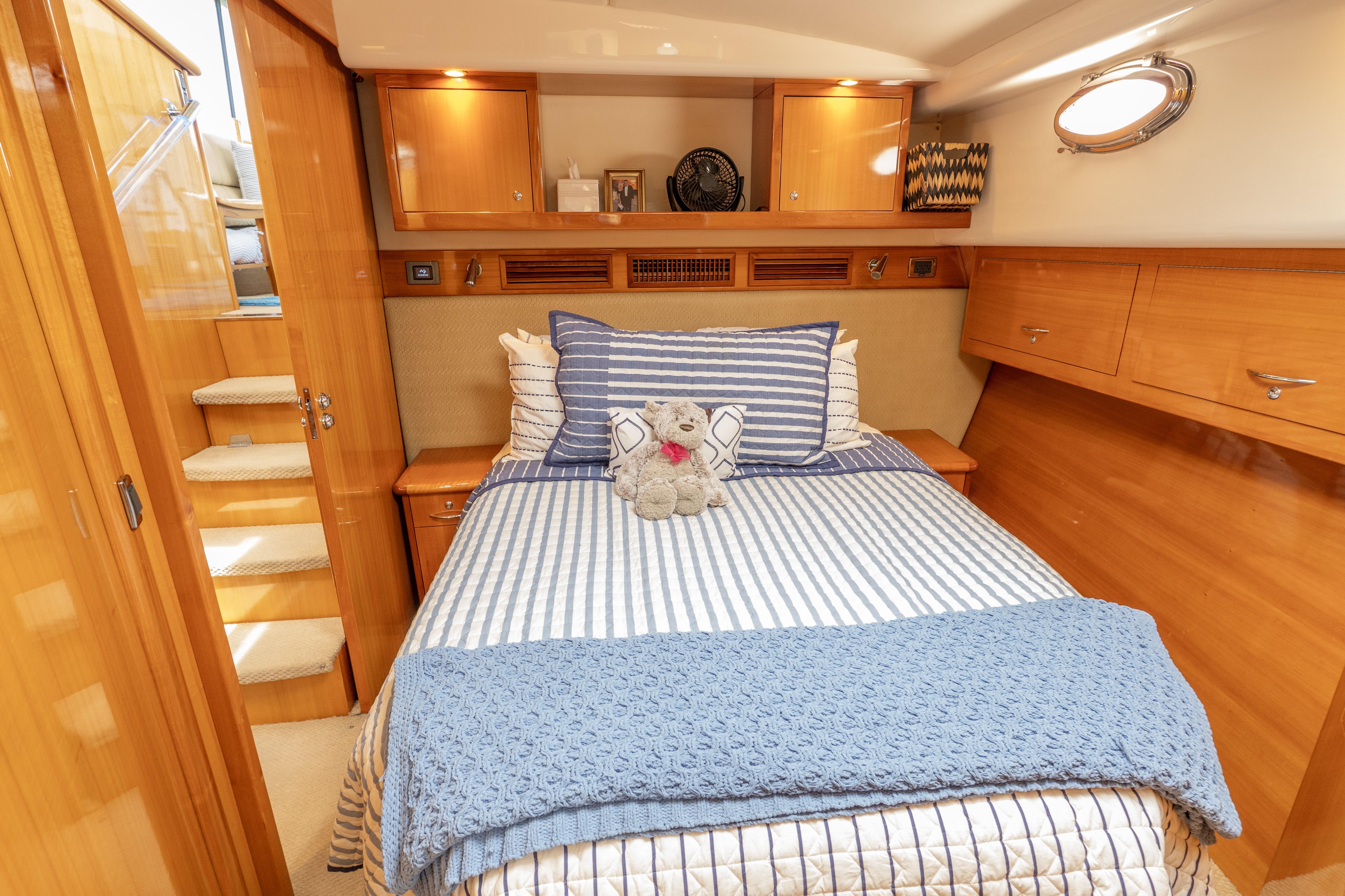 Luxurious cabin interior of 2008 Maritimo 52 yacht with cozy bedding and wooden finishes.