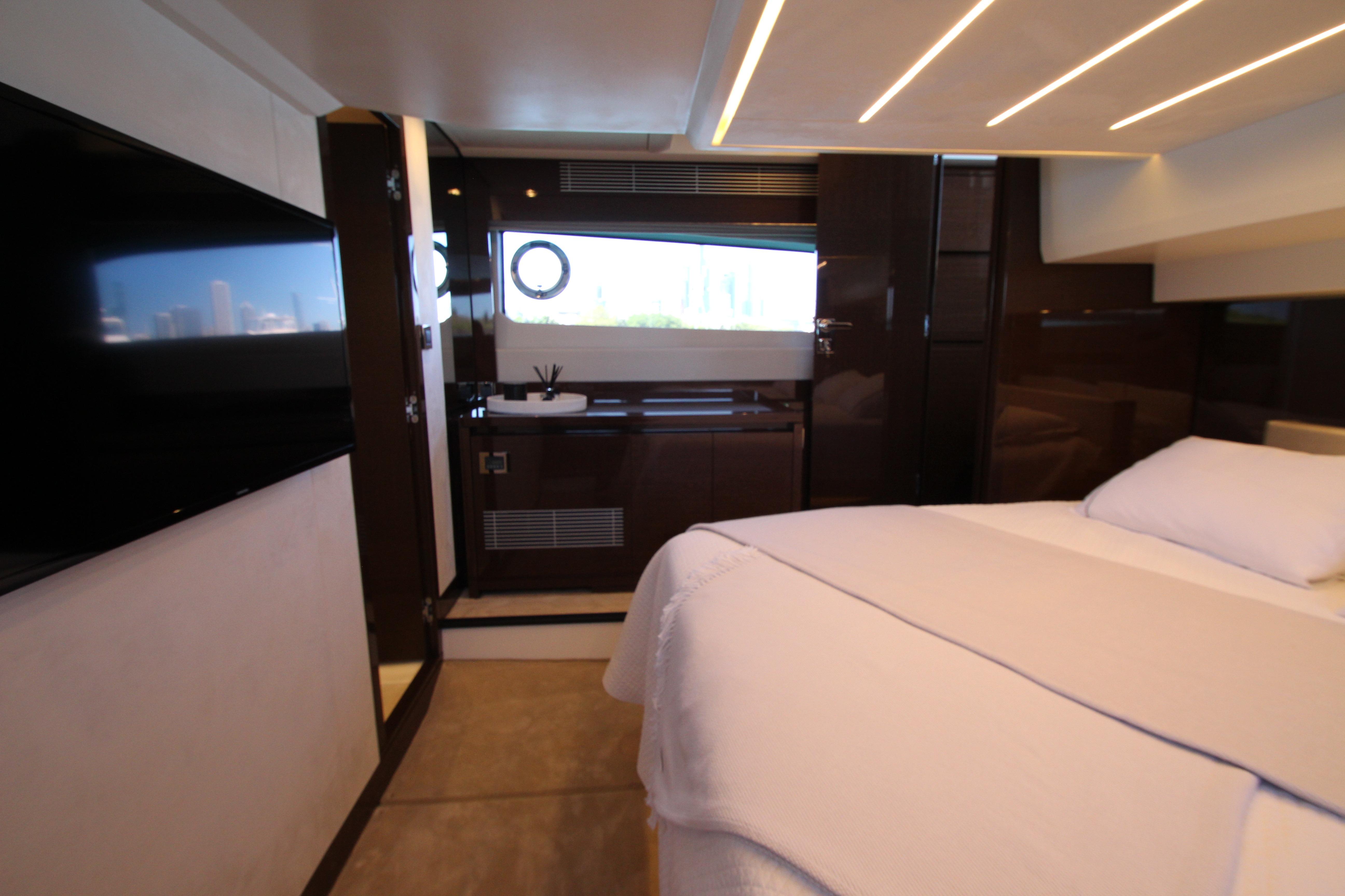 Luxurious interior of a 2022 Prestige 520 yacht bedroom with modern design and elegant lighting.
