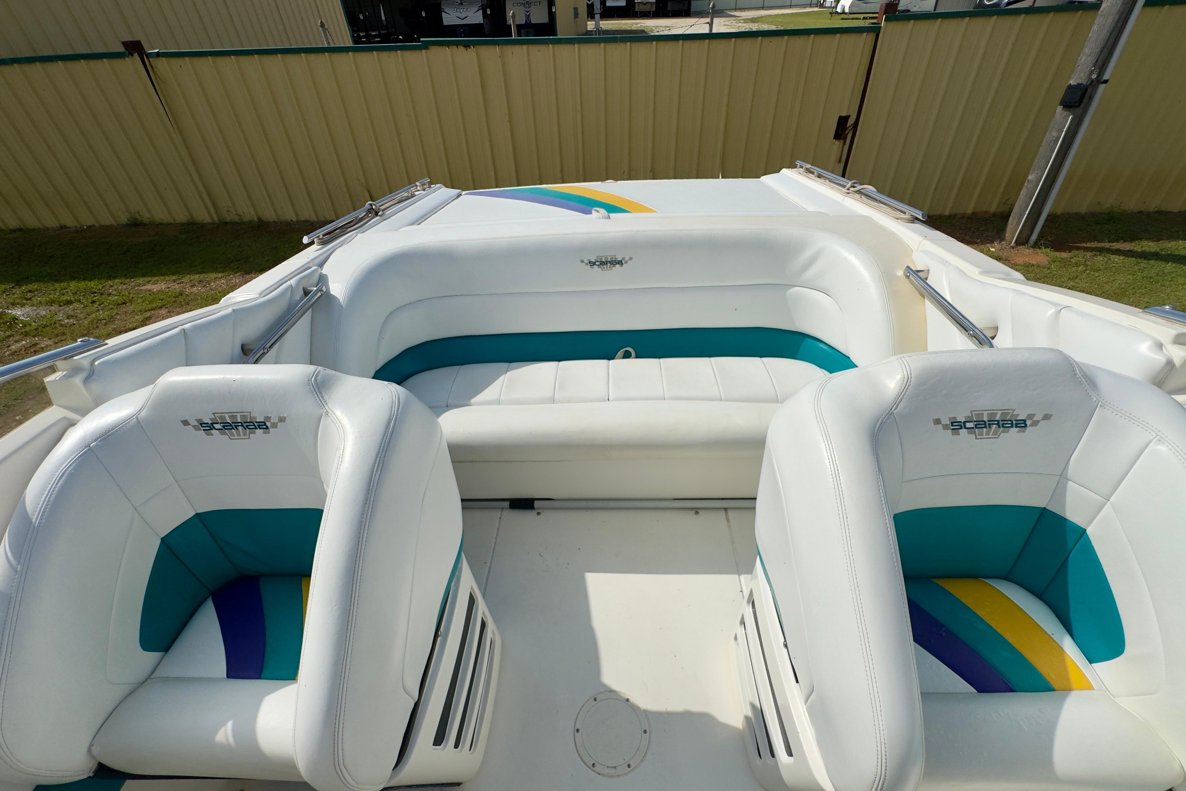 1995 Wellcraft Scarab 31 boat interior with white and teal seating, showcasing stylish design.
