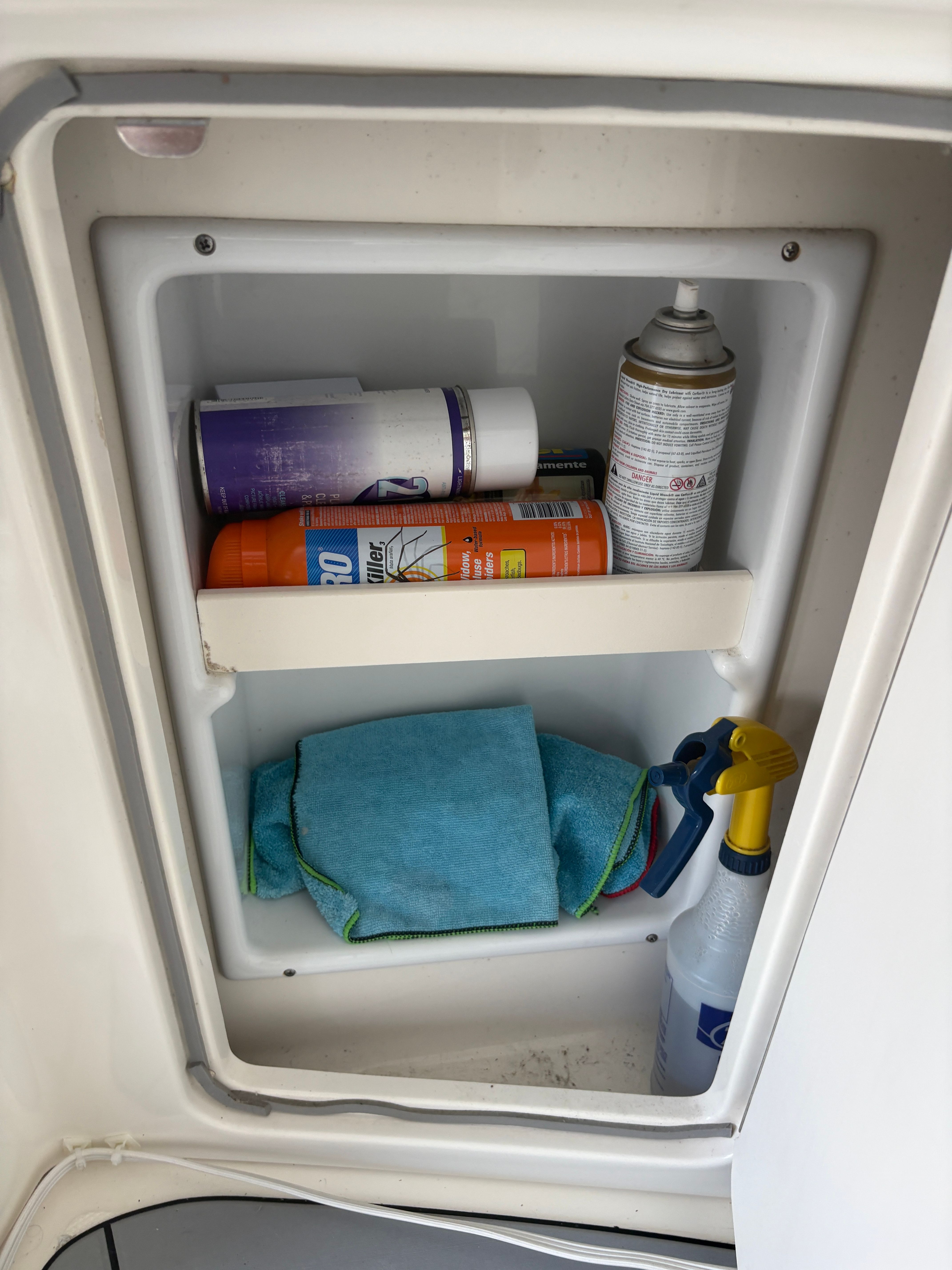 Cleaning supplies in a cabinet on a 2005 Sea Ray 420 Sundancer.