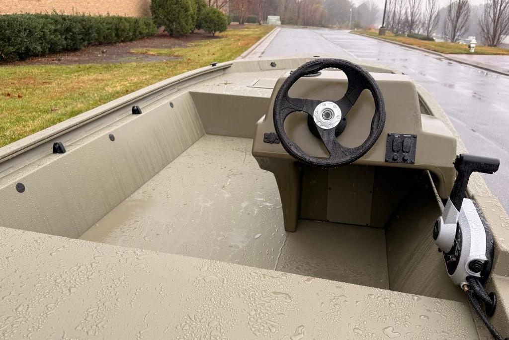 2026 Tracker Grizzly 1648 SC boat interior with steering wheel on a rainy day.