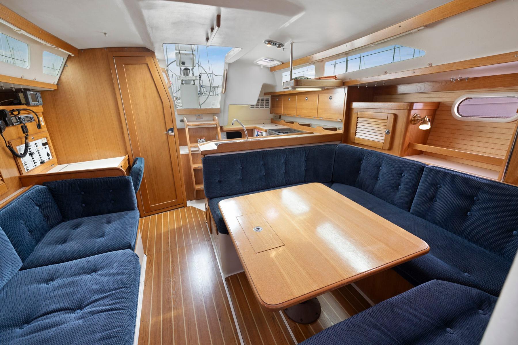 Interior of 2004 Catalina 36 MkII sailboat with wooden furnishings and blue seating.