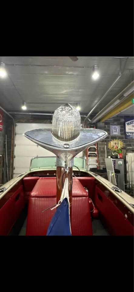 1965 Century Sabre boat with red interior in garage.