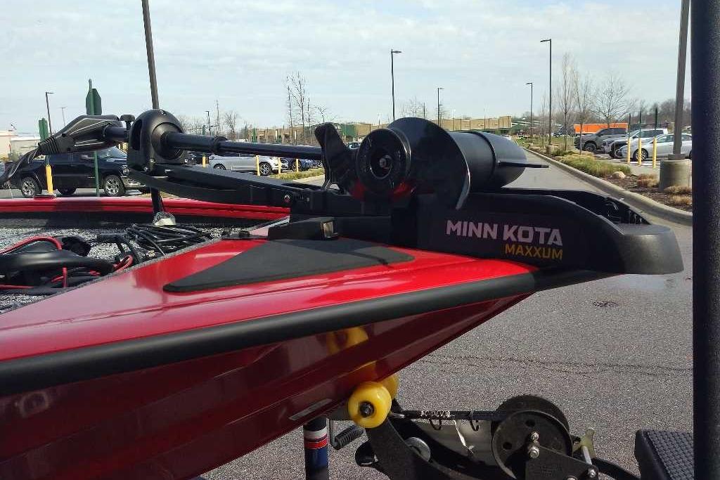 Red Tracker Pro Team 195 boat with Minn Kota Maxxum trolling motor, parked outdoors.