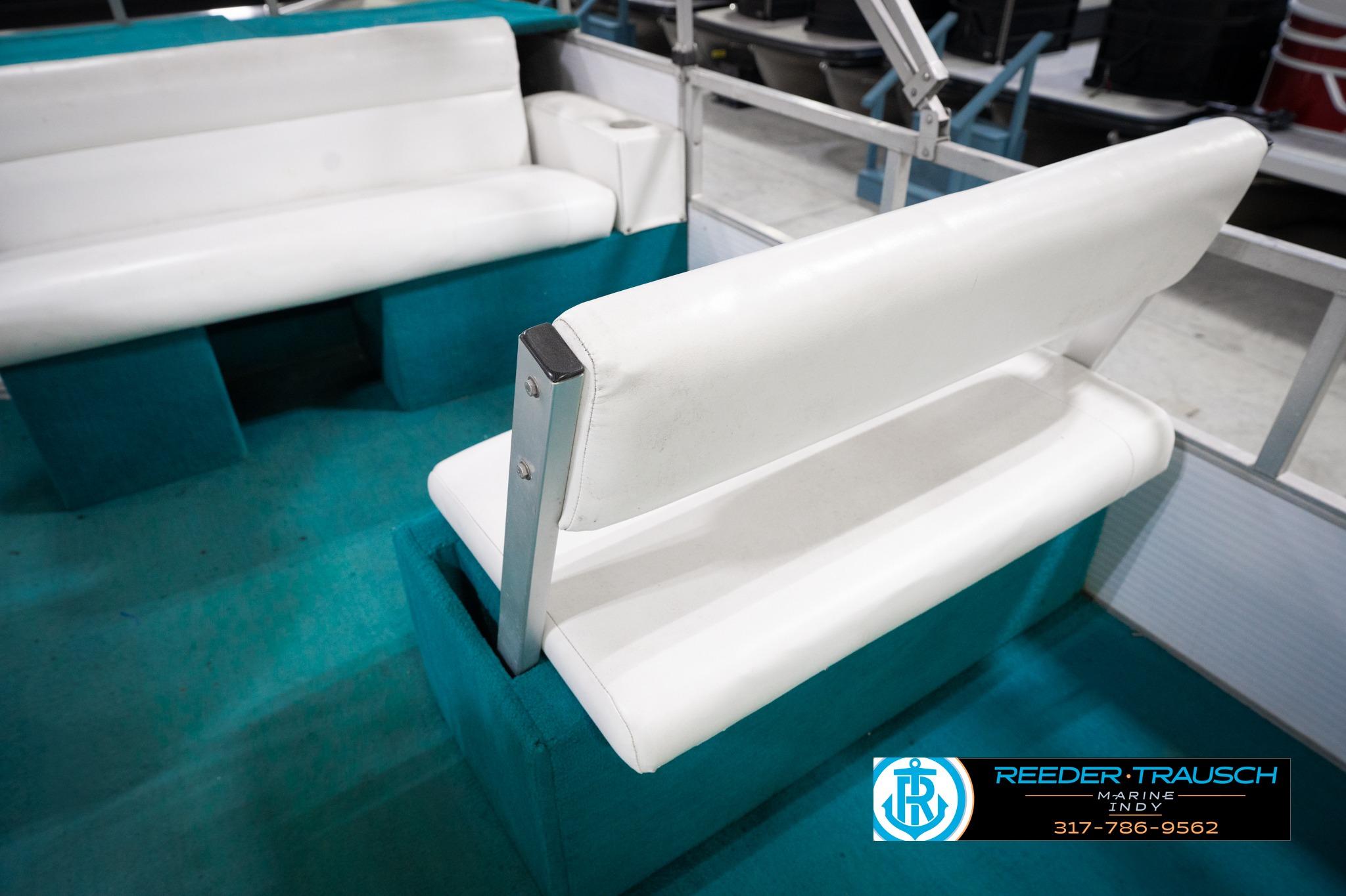 1992 Godfrey Sweetwater boat interior with white seating and teal flooring.