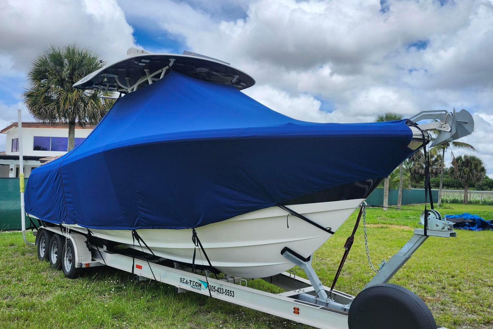 2015 Robalo R300 Center Console boat covered on trailer, parked outdoors.