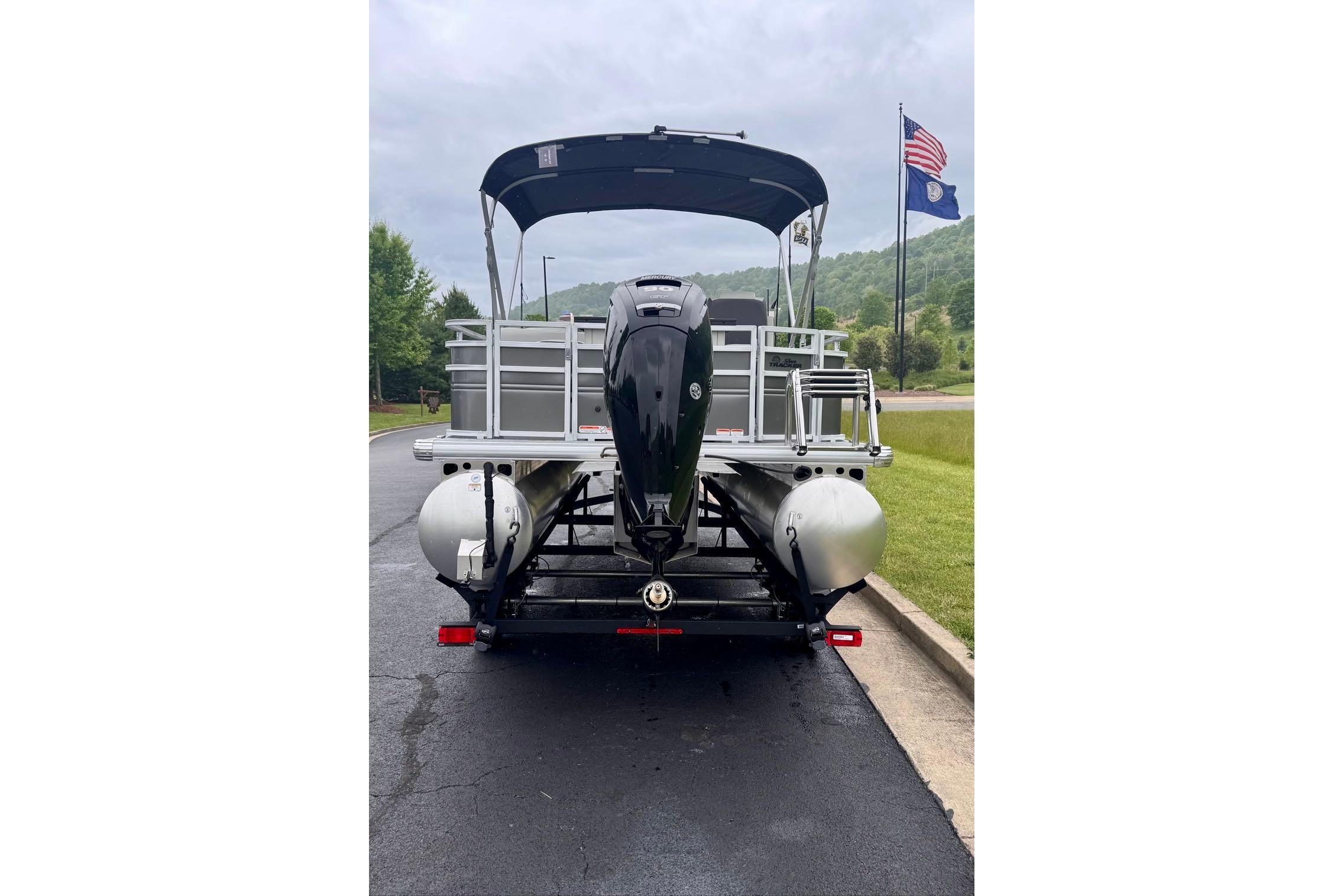 2026 Sun Tracker Fishin' Barge 20 DLX pontoon boat on trailer, rear view.