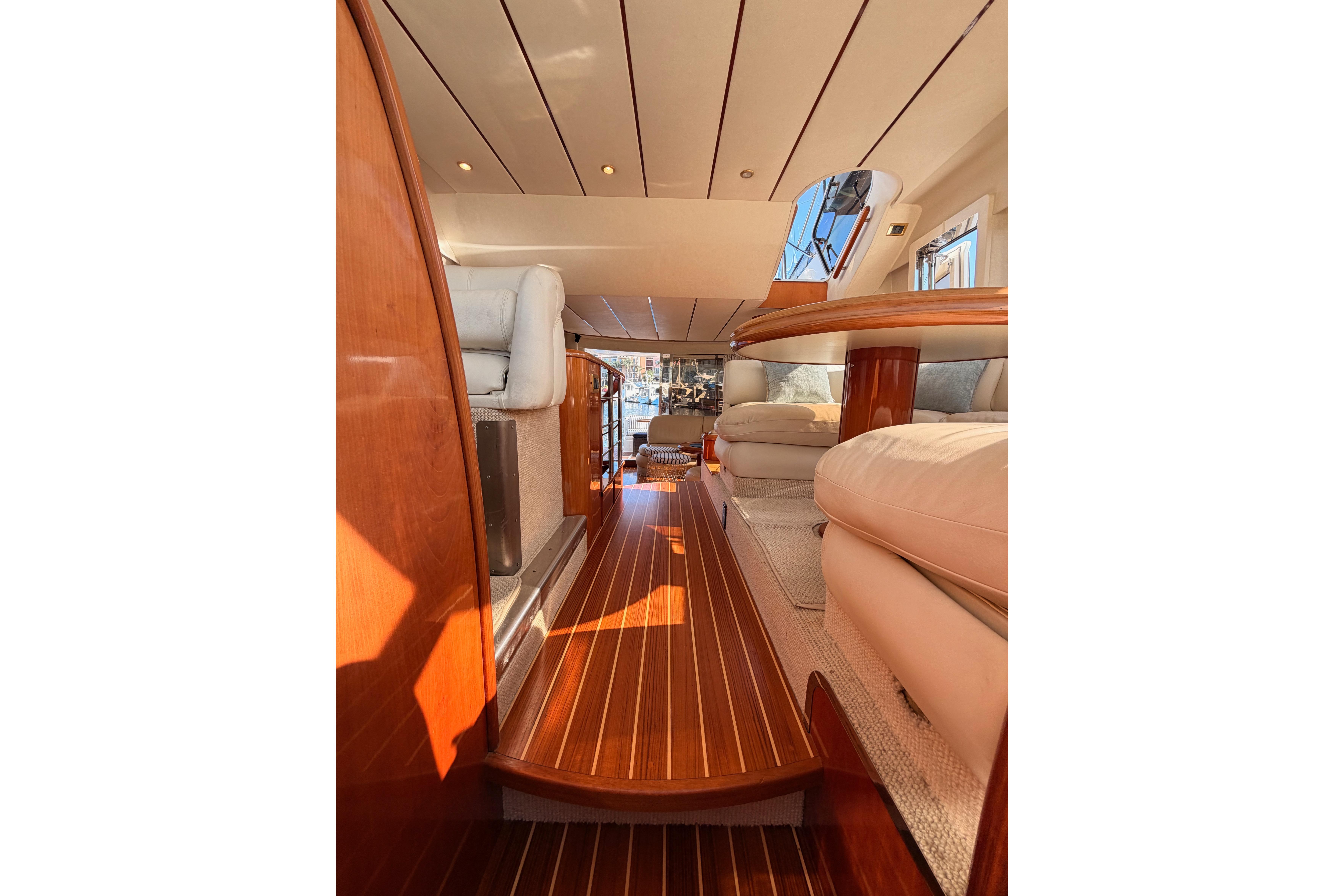 Luxurious interior of a 2001 Fairline 55 yacht with polished wood flooring and plush seating.