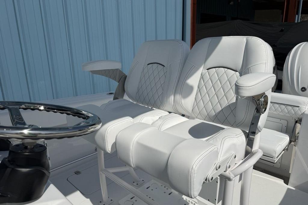 2026 Sportsman Open 252 Center Console boat with luxurious white seating and steering wheel.