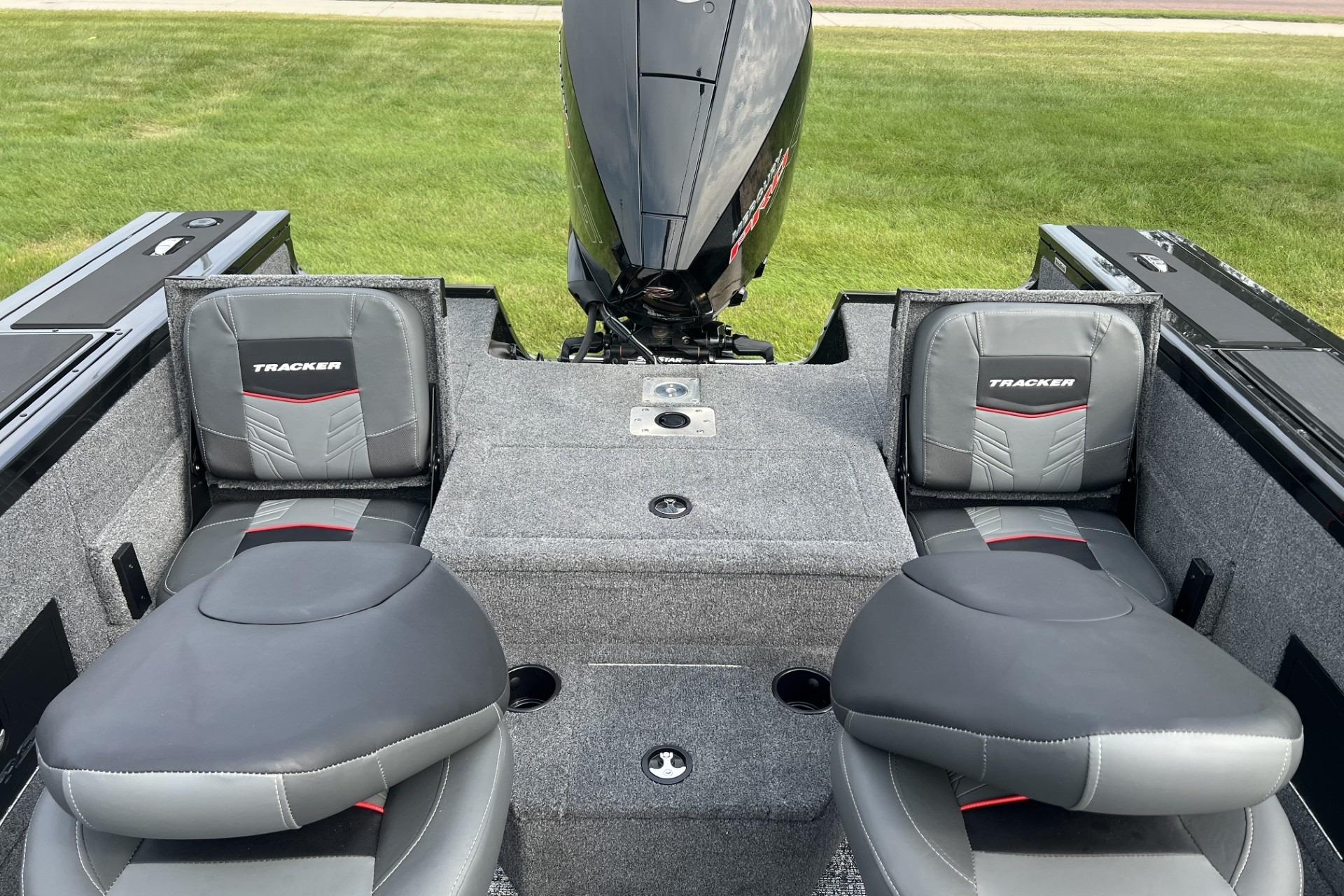 2025 Tracker Targa V-18 Combo boat interior with cushioned seats and motor, on grassy background.